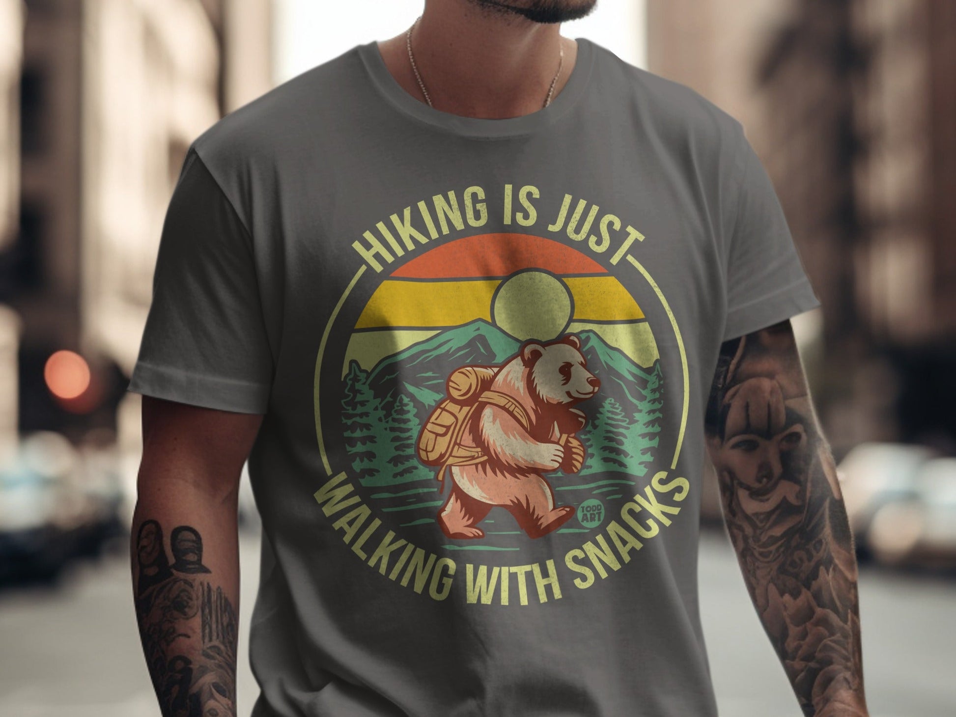Gray t-shirt with bear, mountains, and "Hiking is just walking with snacks" text.