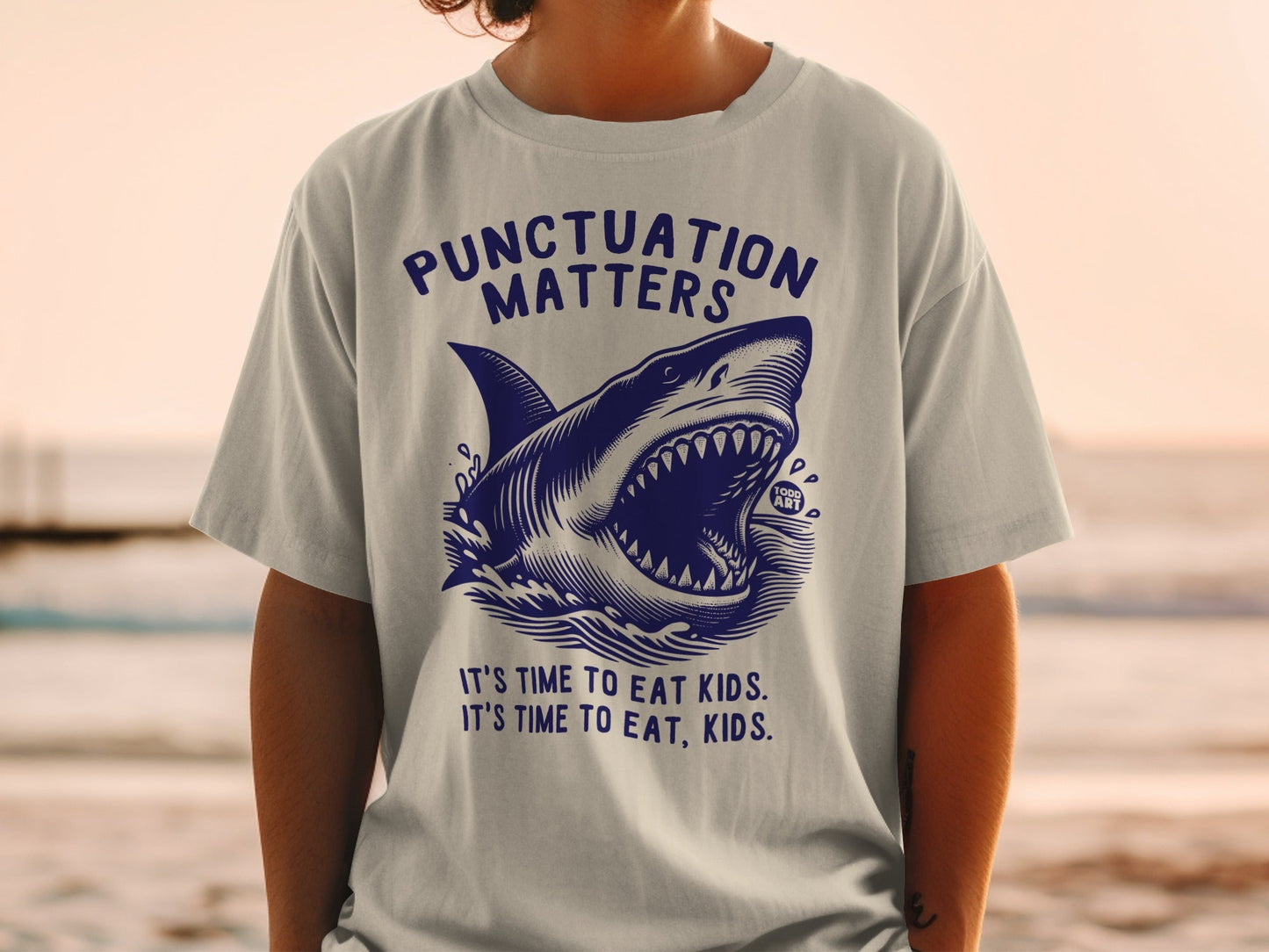 T-shirt with shark graphic and text: "PUNCTUATION MATTERS," "TODD ART," "IT'S TIME TO EAT KIDS. IT'S TIME TO EAT, KIDS."