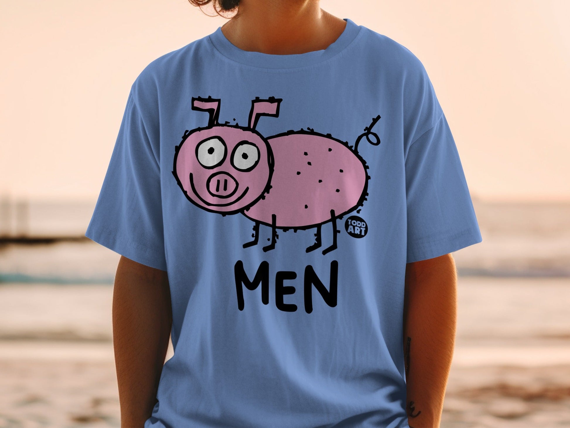 Blue t-shirt with pink pig cartoon and "TODD ART MEN" text.