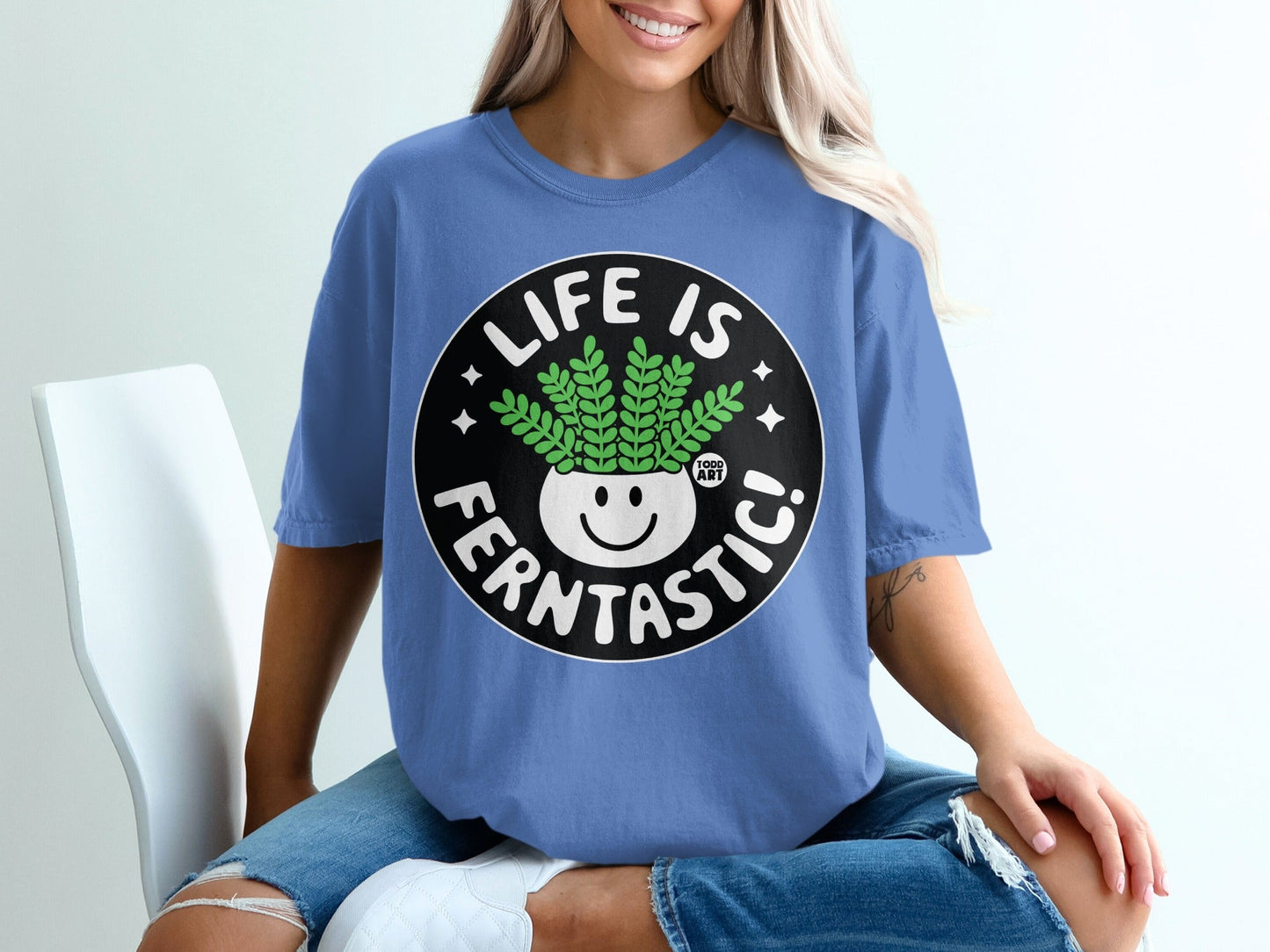 Blue t-shirt with "Life is Ferntastic!" text and a smiling potted plant graphic.