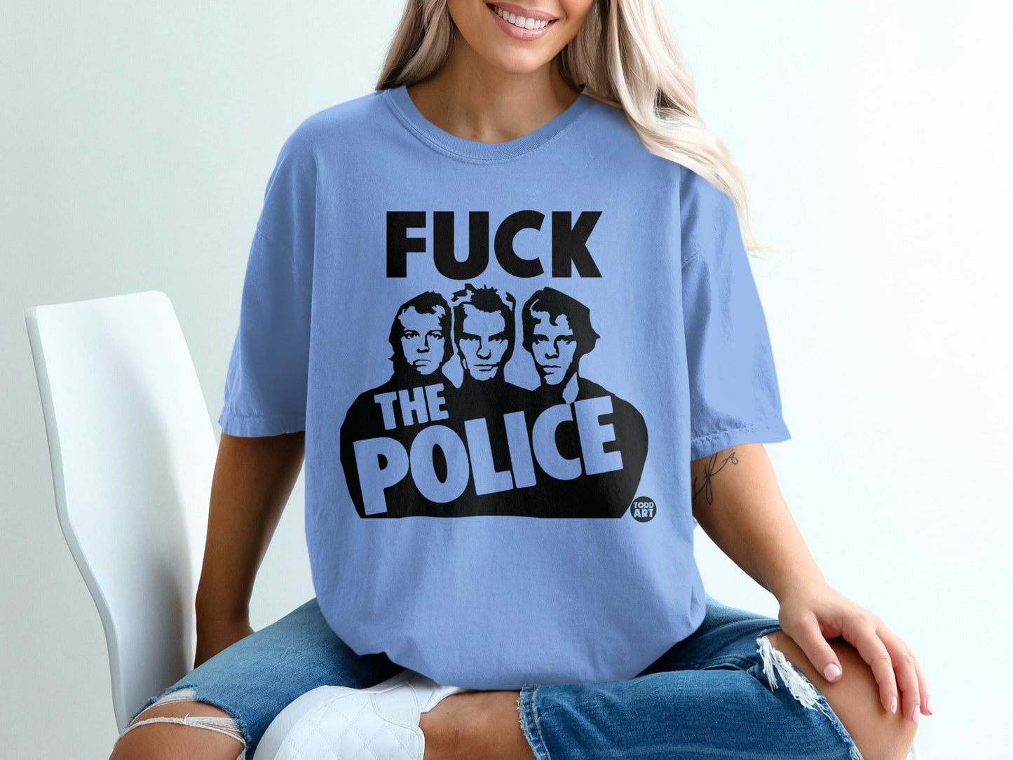 Light blue t-shirt with "FUCK THE POLICE" graphic featuring three men.