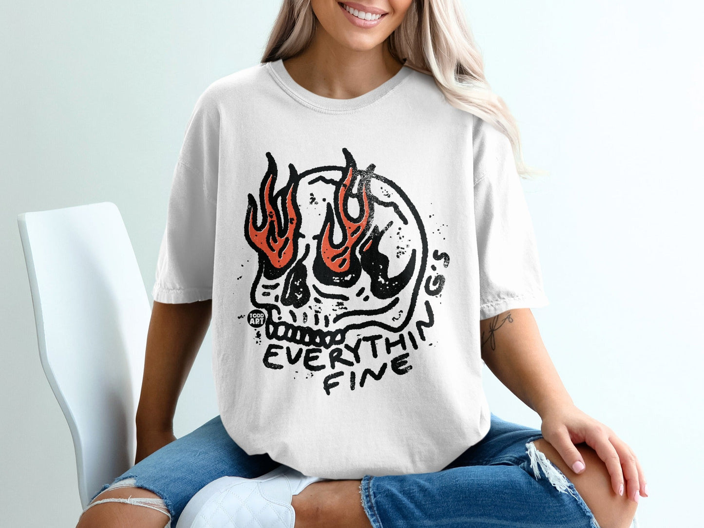 White t-shirt with a flaming skull graphic and "EVERYTHIN FINE" text.