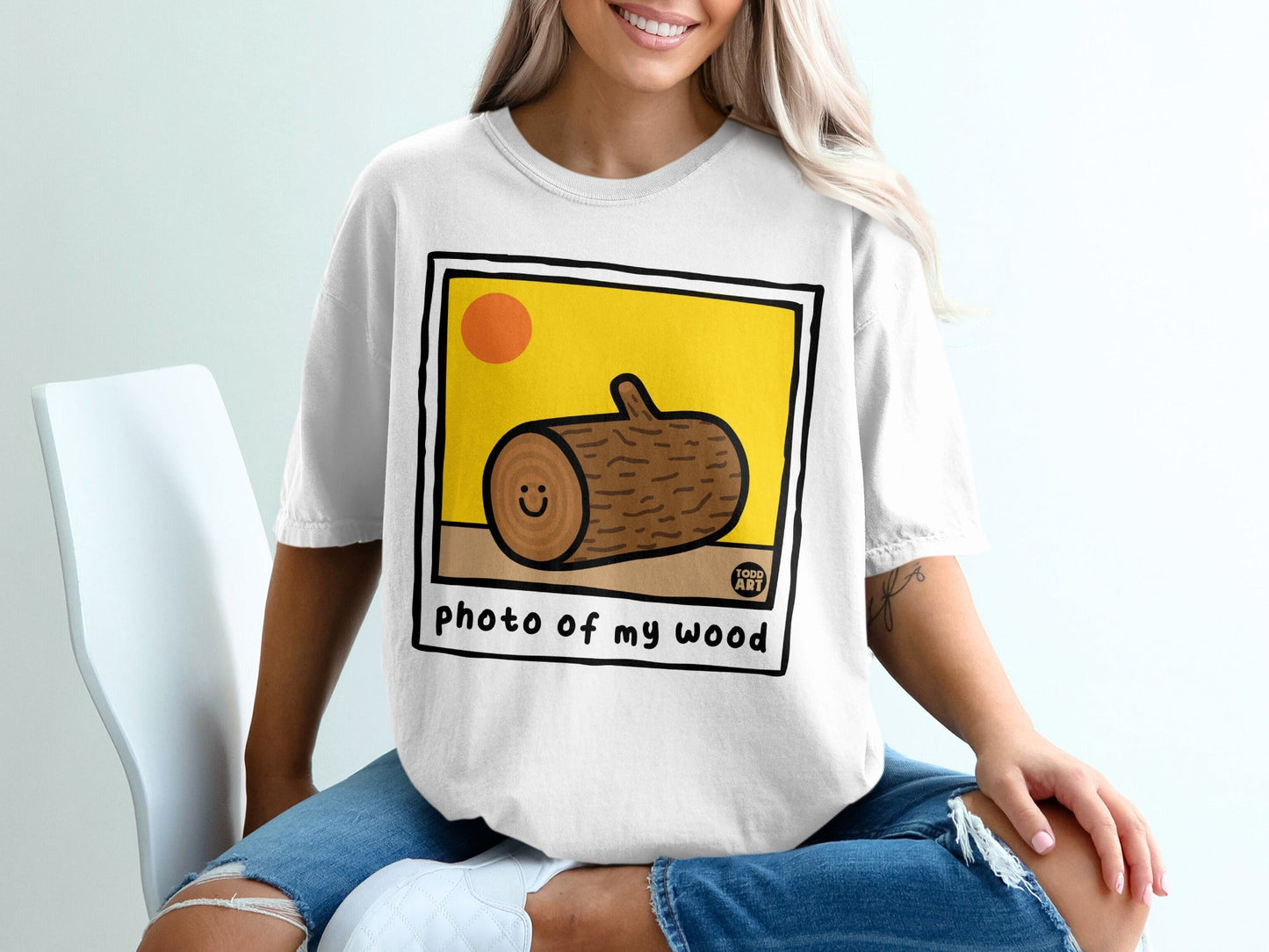 White t-shirt with cartoon wood log on yellow background, text "photo of my wood".