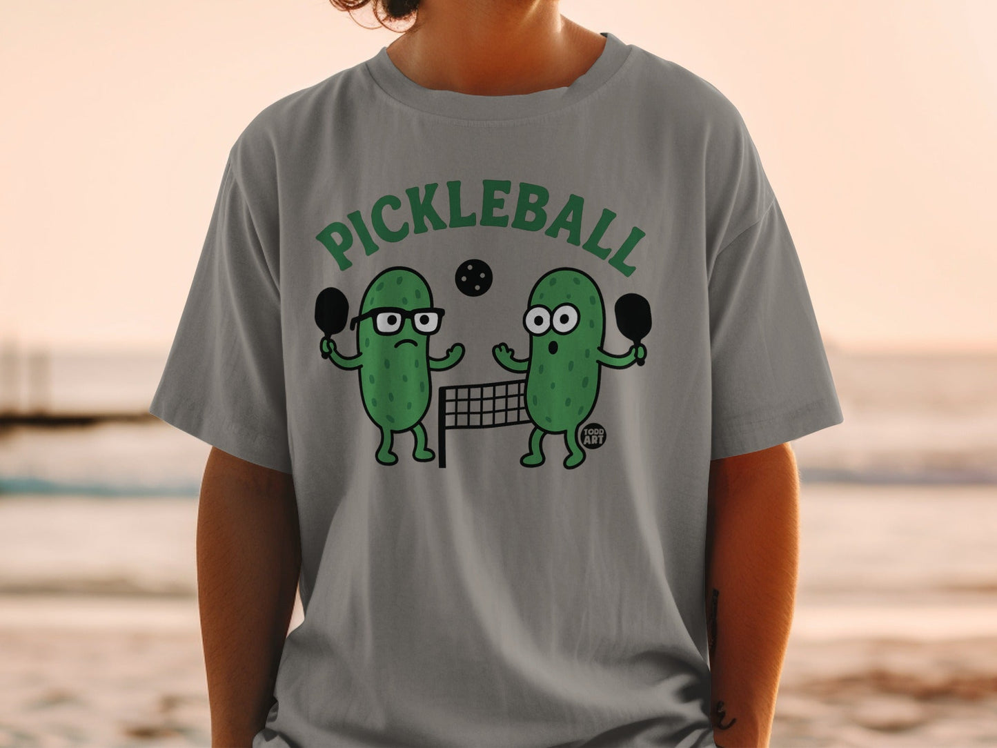 Cartoon pickle characters playing pickleball on a net.