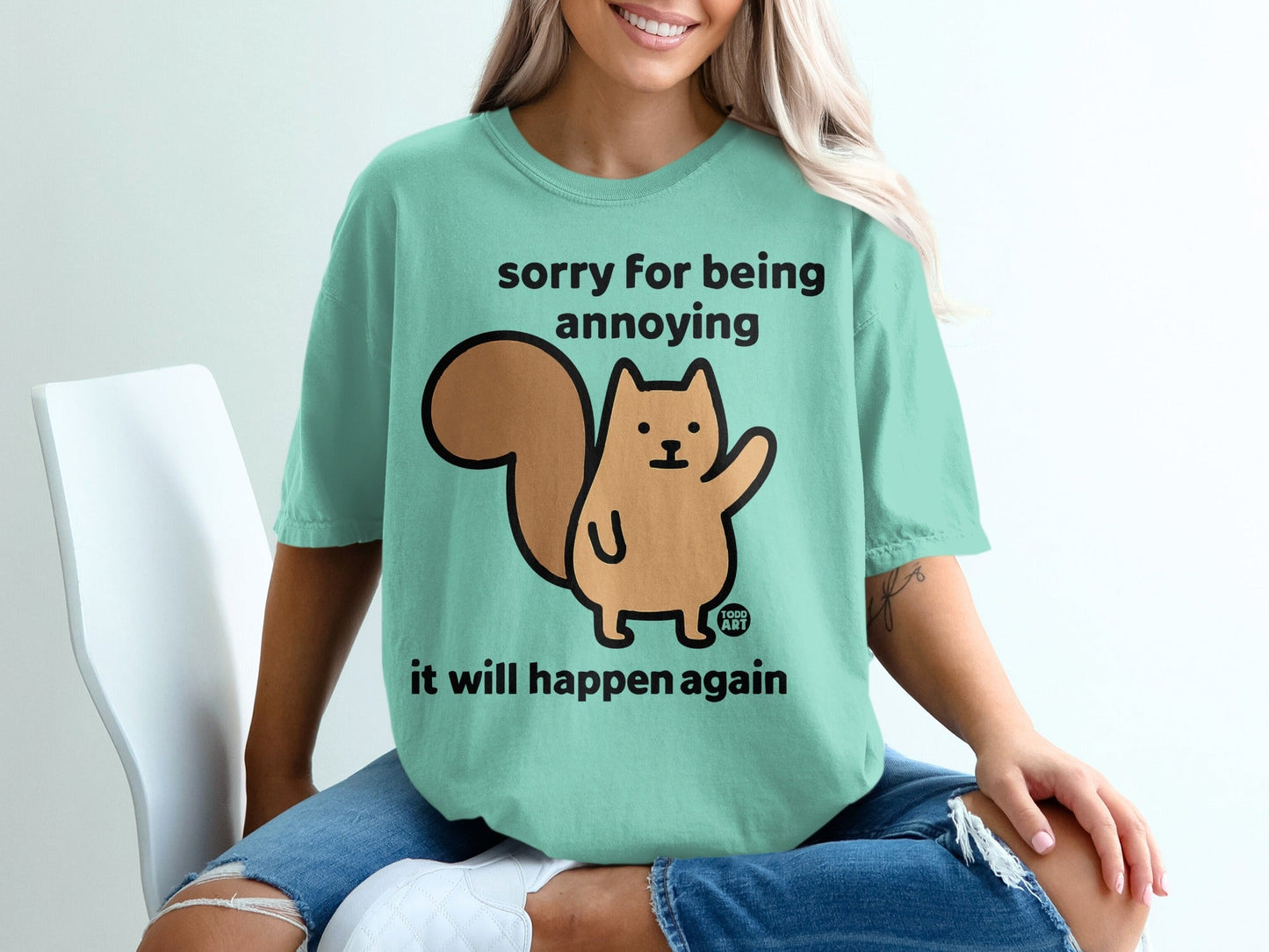 Mint t-shirt with a cartoon squirrel saying "sorry for being annoying it will happen again".