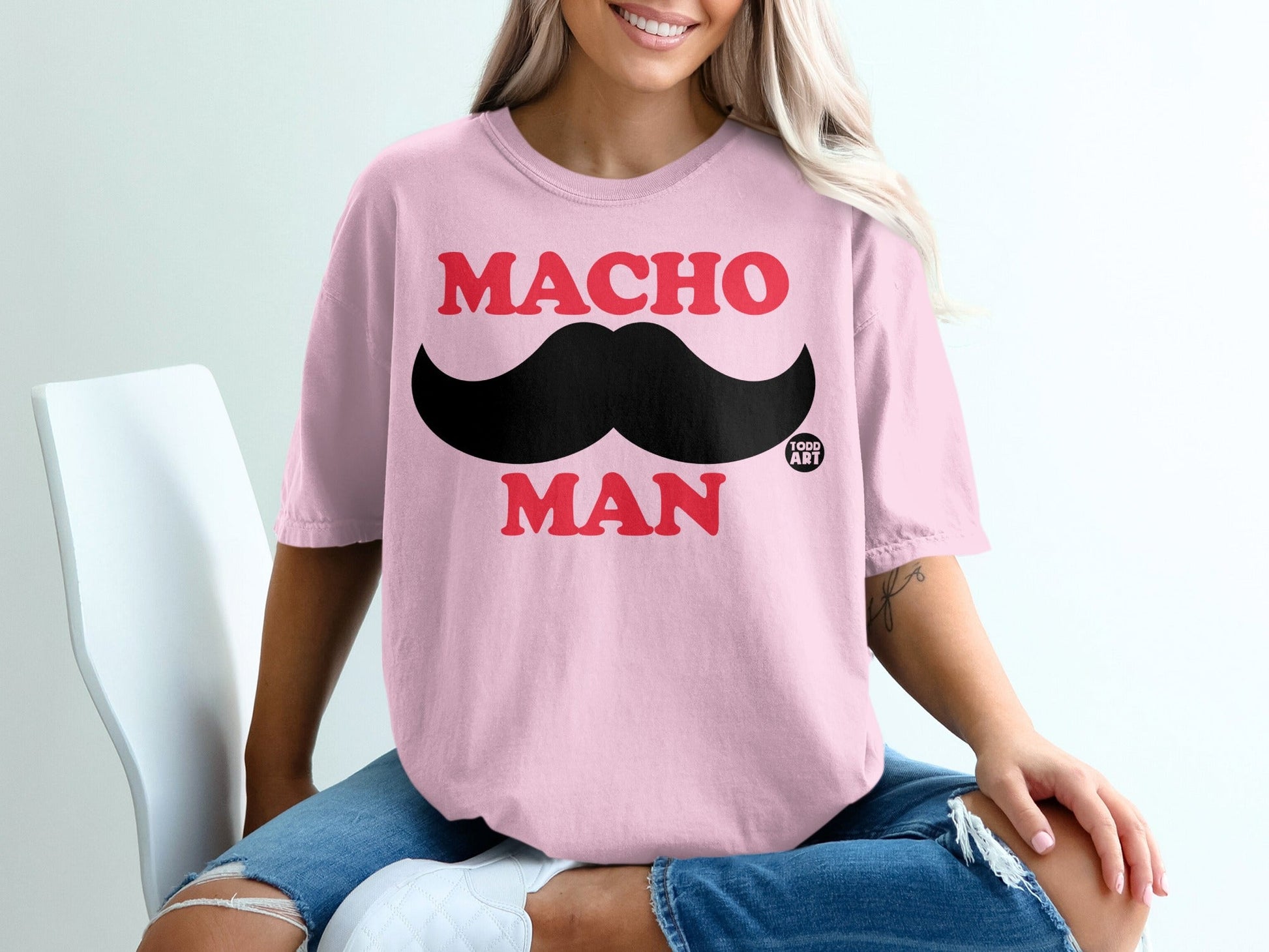 Pink t-shirt with black mustache graphic and "MACHO MAN" text.