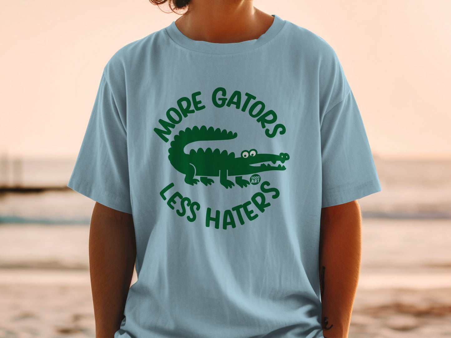 Light blue t-shirt with green "More Gators Less Haters" text and alligator graphic.
