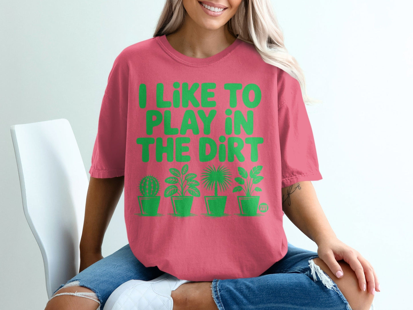 Pink t-shirt with green text "I LIKE TO PLAY IN THE DIRT" and plant graphics.