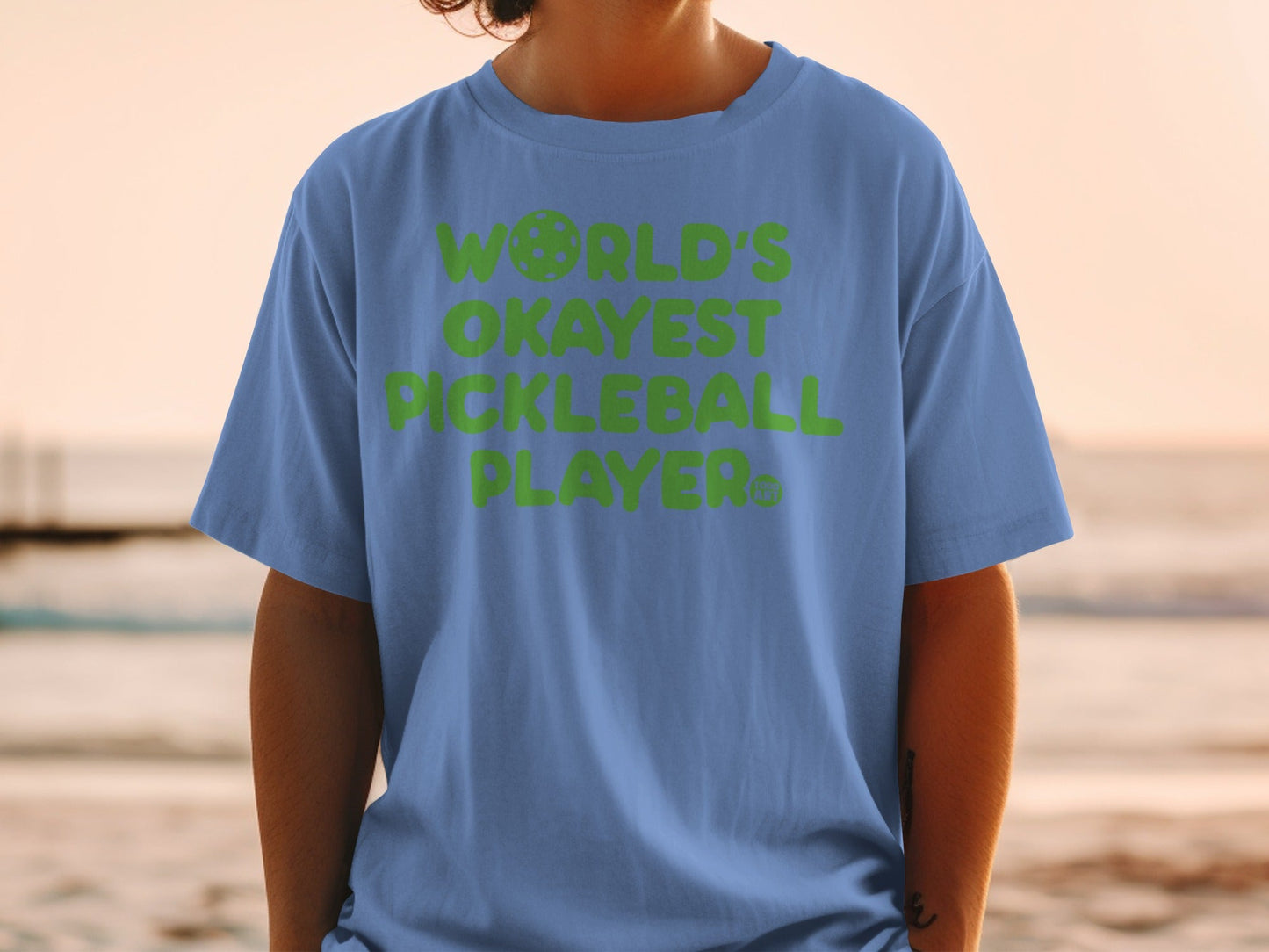 Blue t-shirt with "WORLD'S OKAYEST PICKLEBALL PLAYER" in green text.