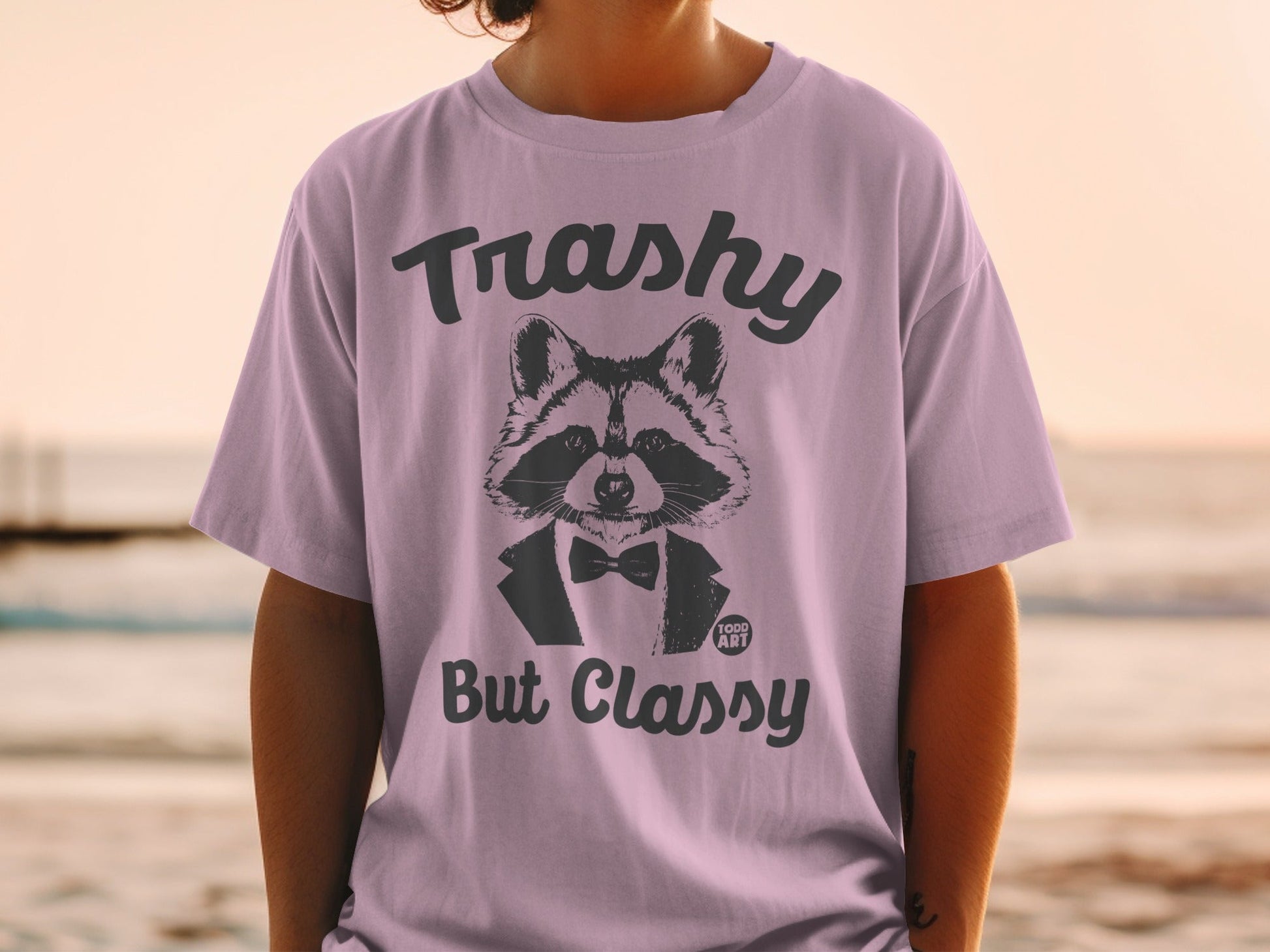 T-shirt with raccoon wearing bowtie and text "Trashy But Classy".