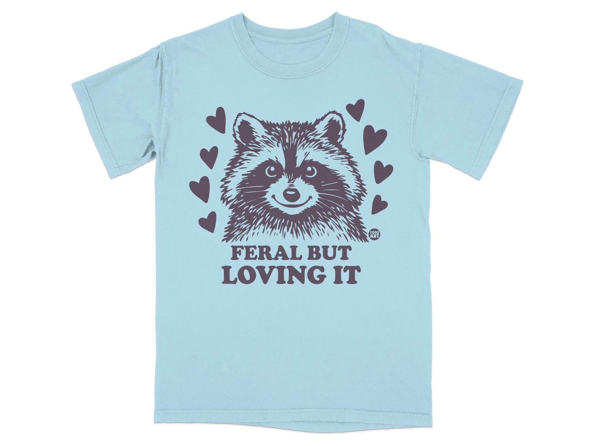 Light blue t-shirt with raccoon and "FERAL BUT LOVING IT" text.