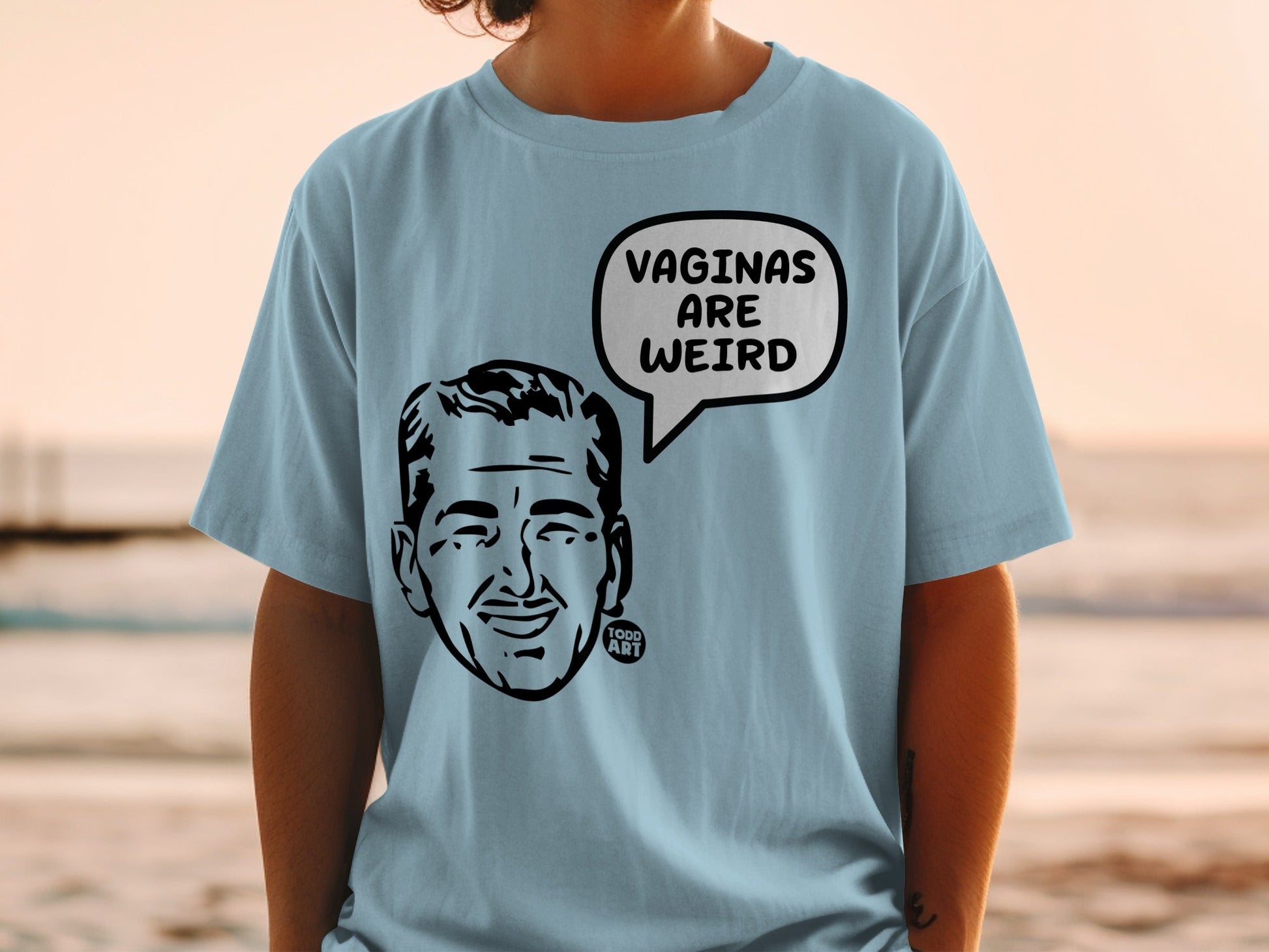 Light blue t-shirt with a black and white illustration of a man's head in a speech bubble.