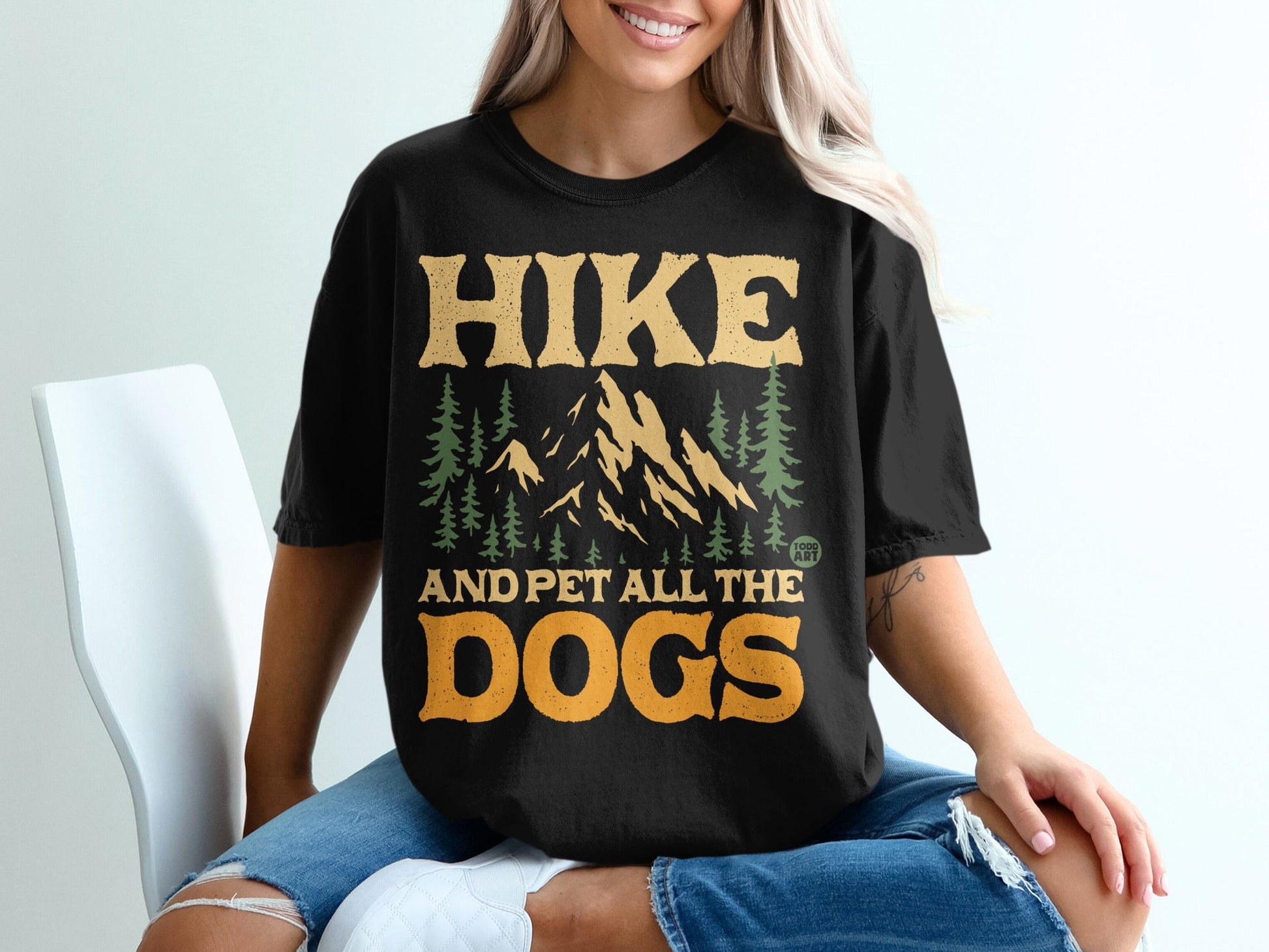 Black t-shirt with "Hike and Pet All the Dogs" text and mountain graphic.