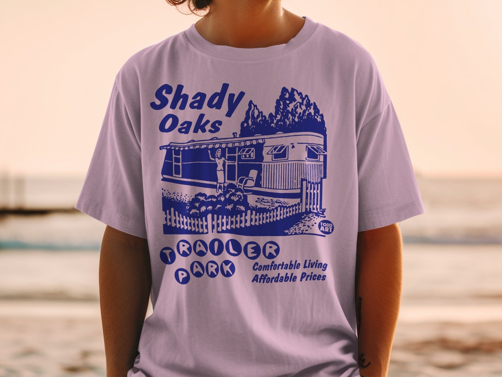Purple t-shirt with Shady Oaks Trailer Park graphic and text.