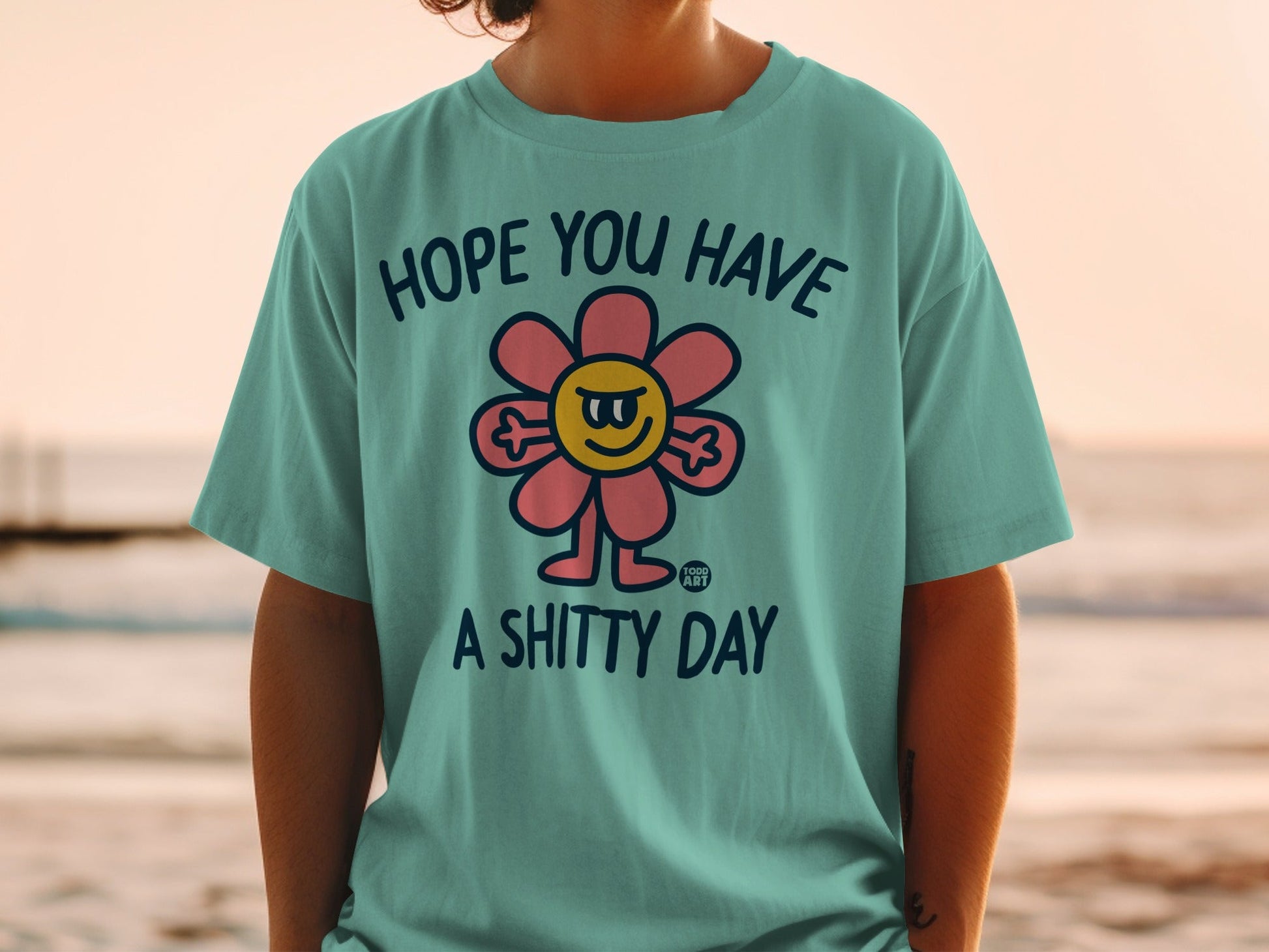 Teal t-shirt with flower graphic and text "HOPE YOU HAVE A SHITTY DAY".