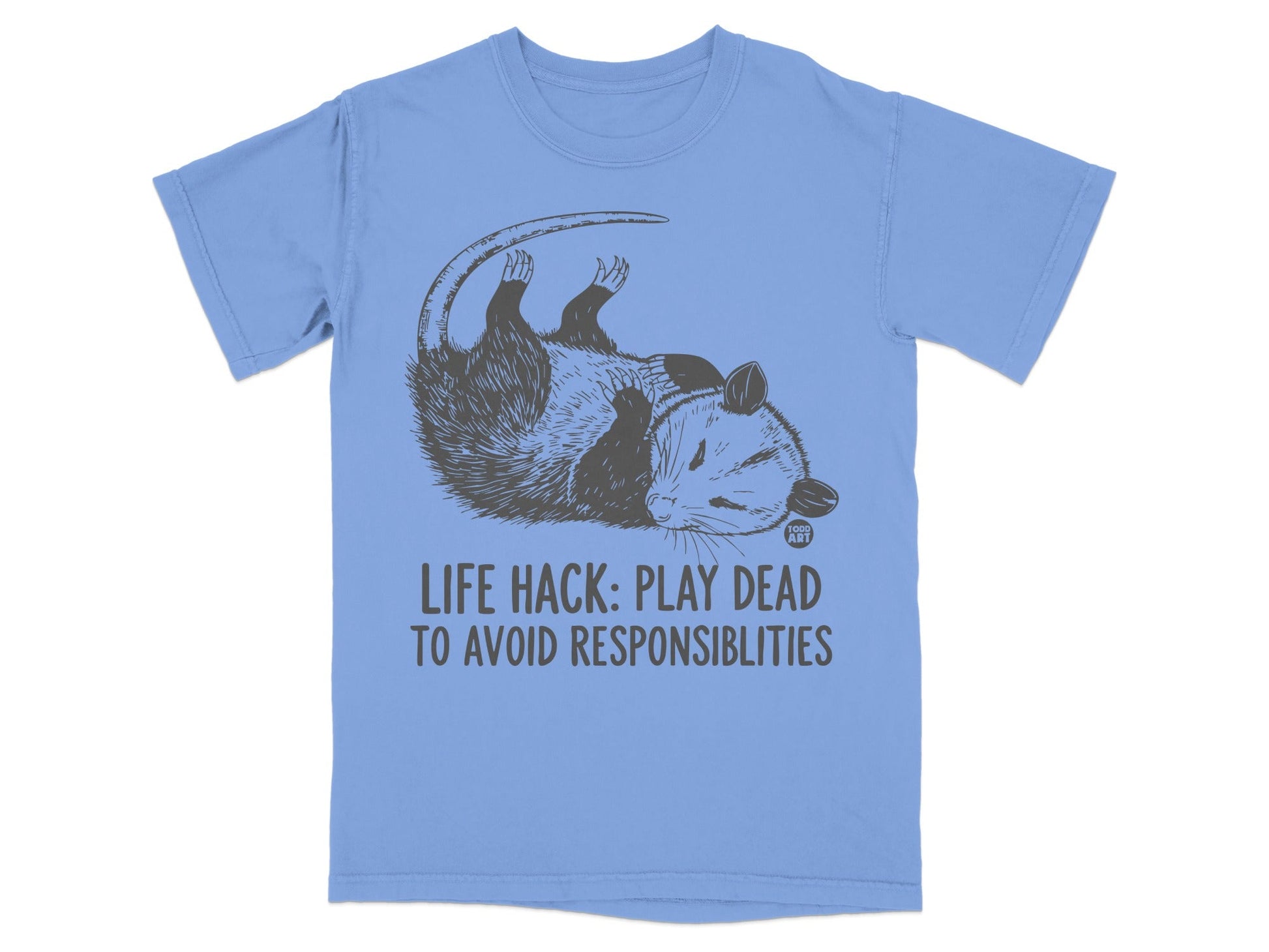 Light blue t-shirt with a graphic of a possum playing dead and text that says "LIFE HACK: PLAY DEAD TO AVOID RESPONSIBILITIES".
