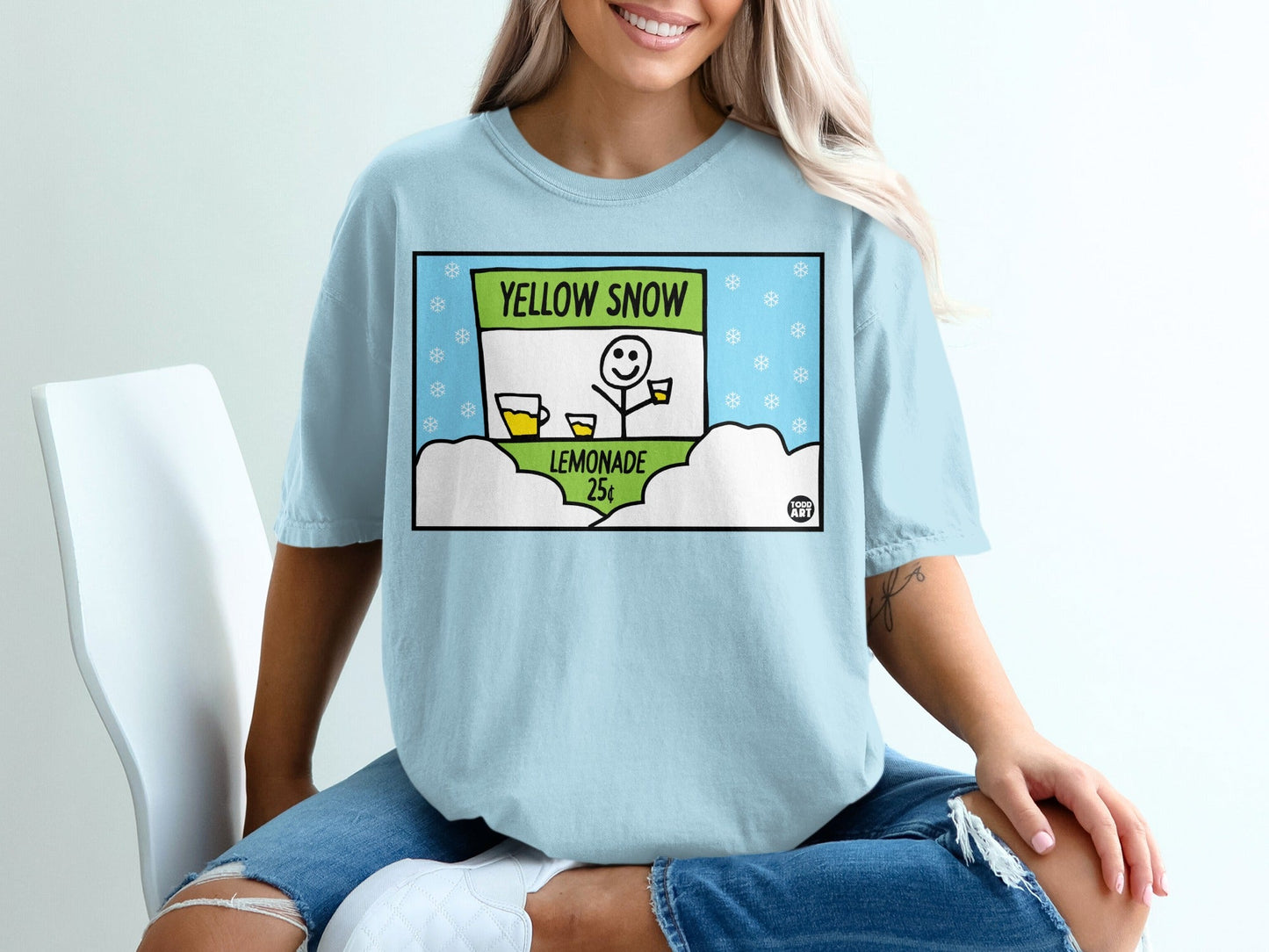 Light blue t-shirt with cartoon lemonade stand, "Yellow Snow Lemonade 25¬¢" text.