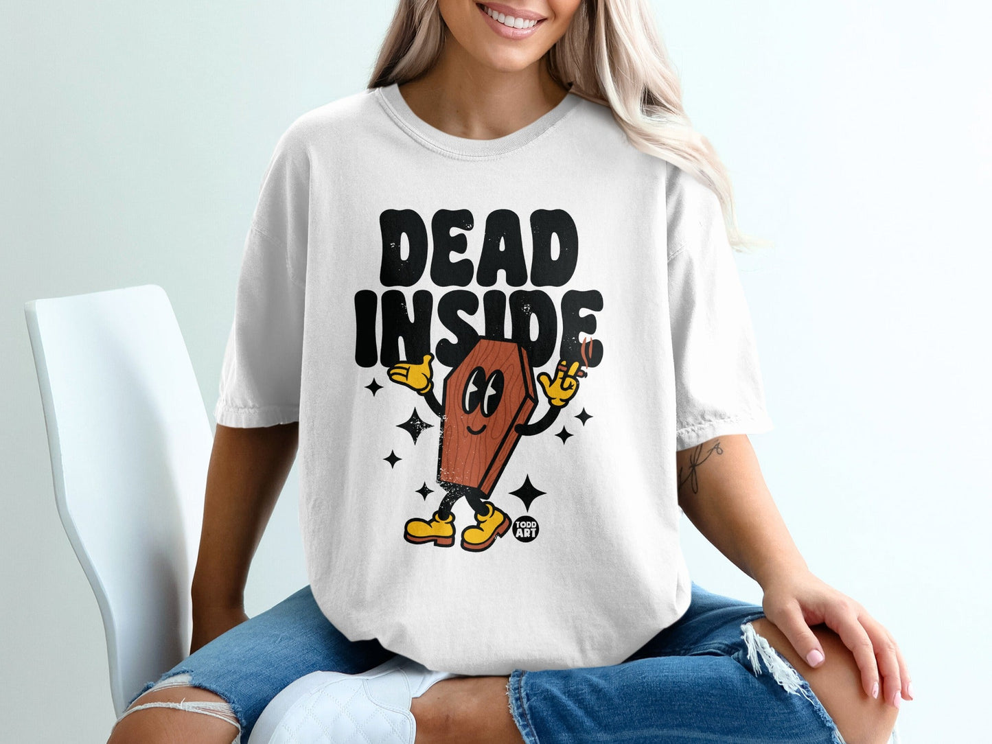 White t-shirt with "DEAD INSIDE" text and cartoon coffin character.
