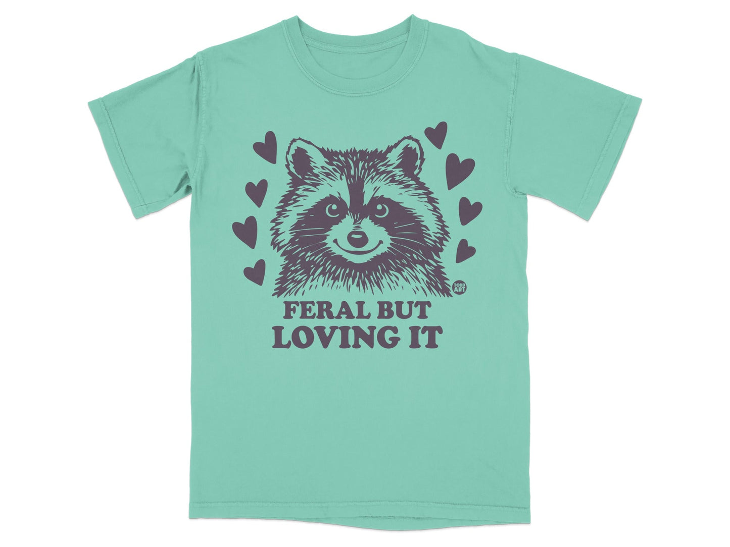 Teal t-shirt with raccoon graphic and text "FERAL BUT LOVING IT".