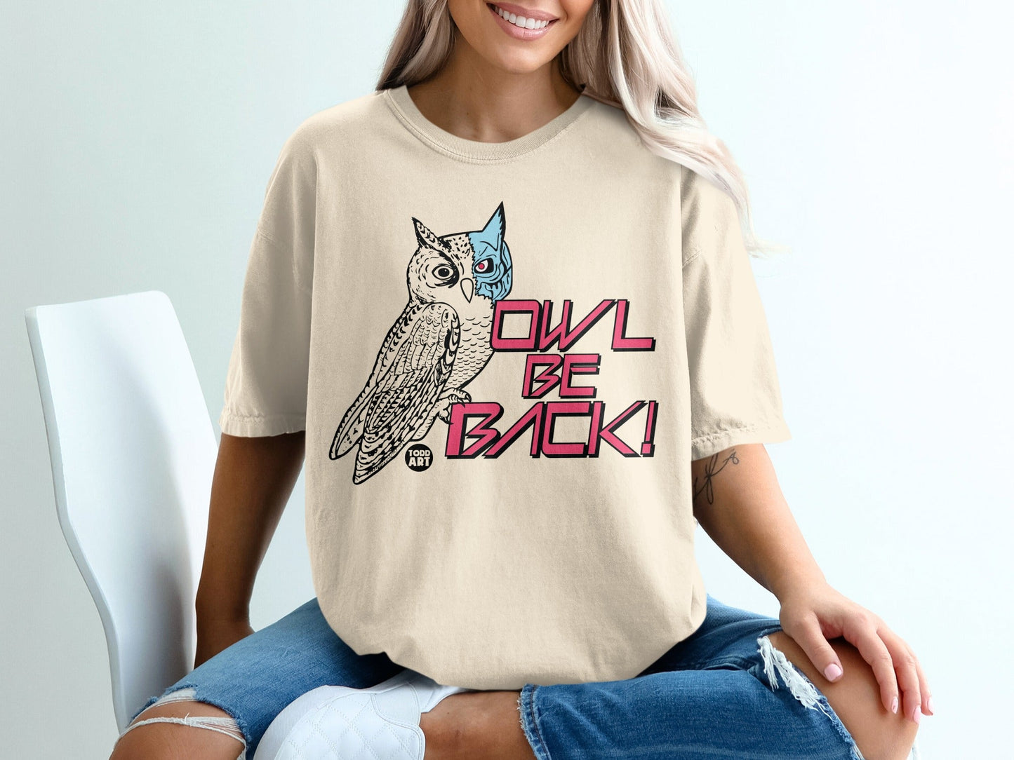 T-shirt featuring a stylized owl with pink text reading "OWL BE BACK!".