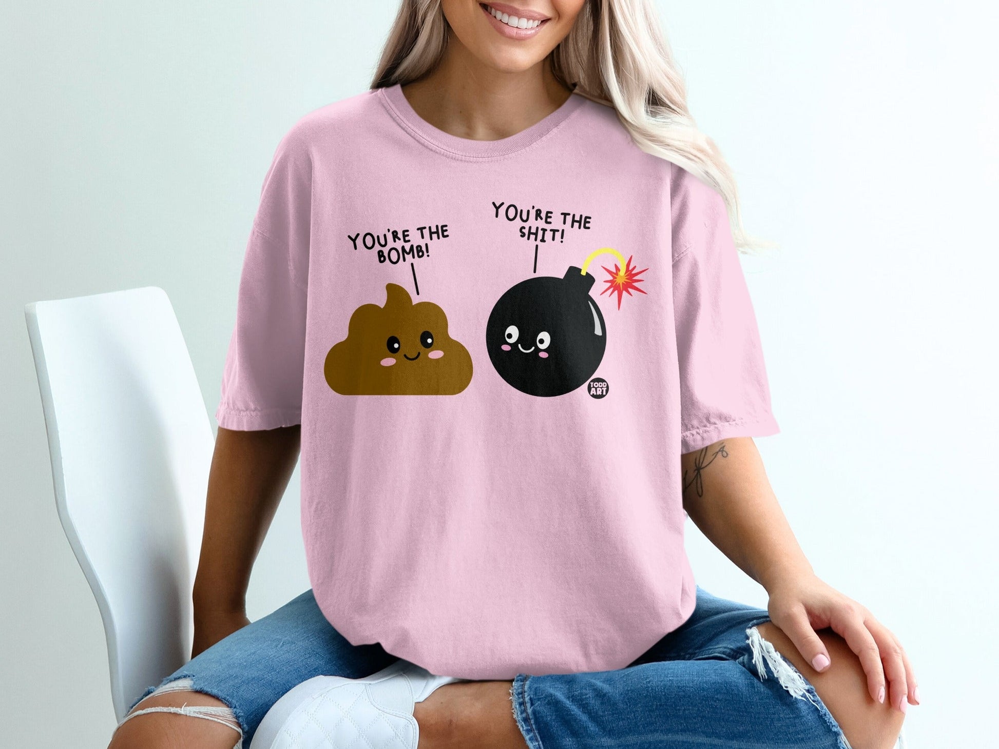 Pink t-shirt with cartoon bomb and poop emojis saying "You're the bomb!"