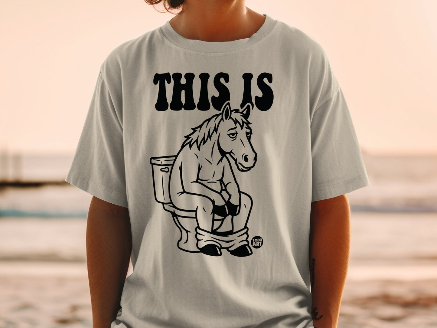 T-shirt with a horse sitting on a toilet, text reads "THIS IS".