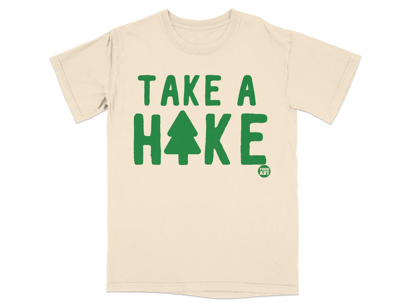 Cream t-shirt with green text "TAKE A HIKE" and a pine tree graphic.