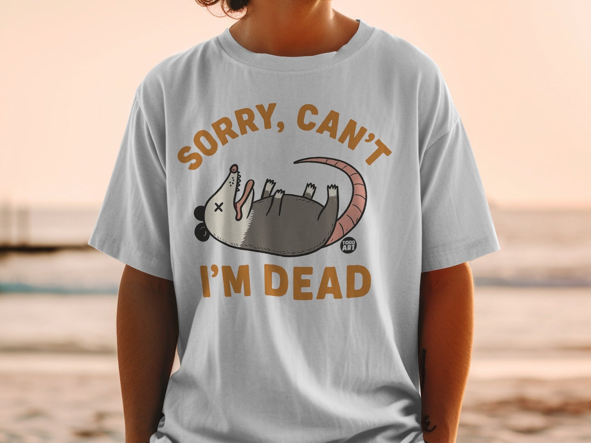 T-shirt with cartoon possum and text "Sorry, Can't I'm Dead."