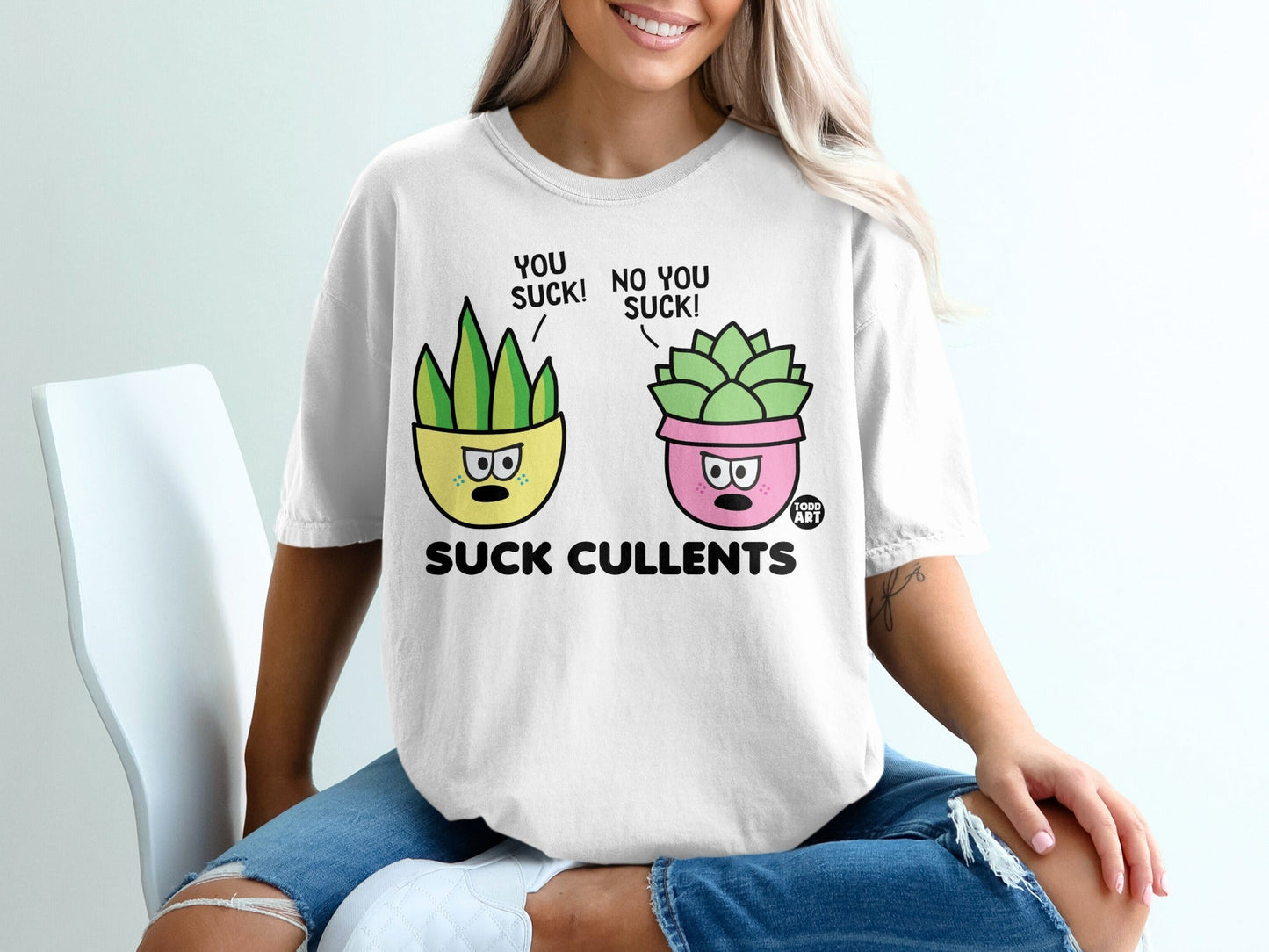 White t-shirt with cartoon succulents saying "You suck!" and "No you suck!".