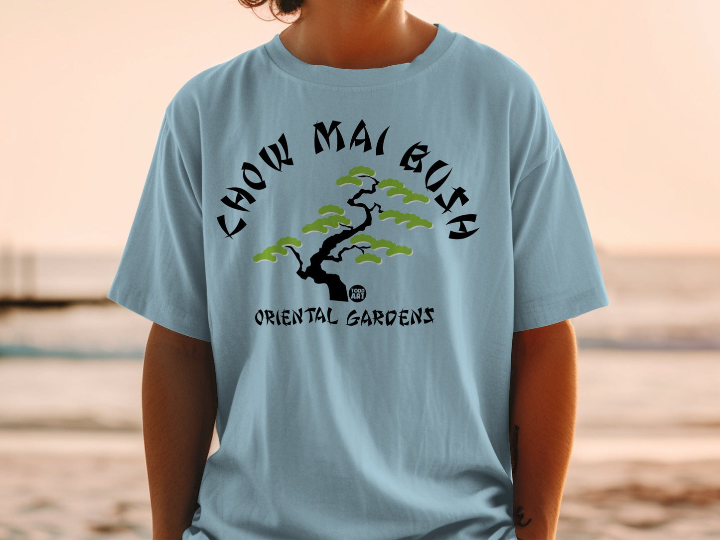 Light blue t-shirt with "CHOW MAI BUSH" and "ORIENTAL GARDENS" text.