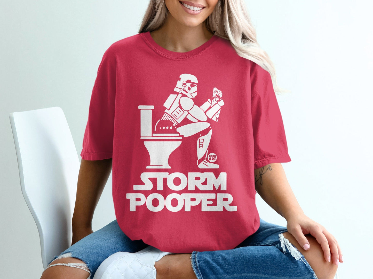 Red t-shirt with white "STORM POOPER" text and stormtrooper on toilet.