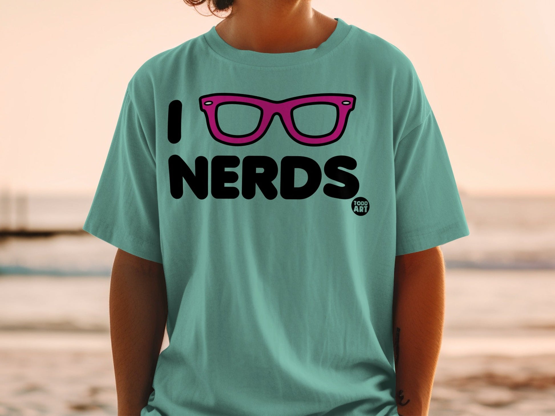 Teal t-shirt with "I NERDS" and pink glasses graphic.
