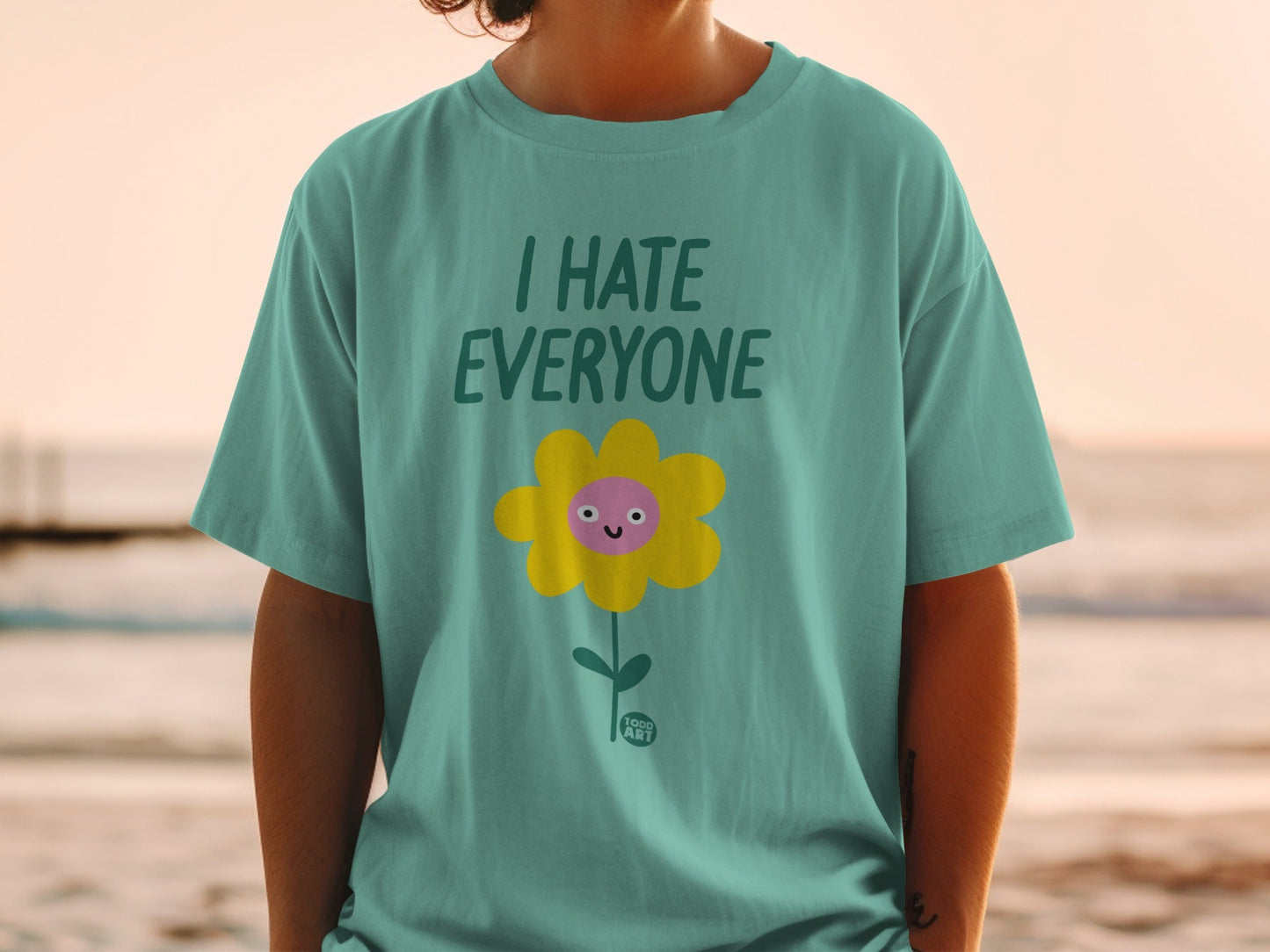 Teal t-shirt with a yellow cartoon flower and "I HATE EVERYONE" text.