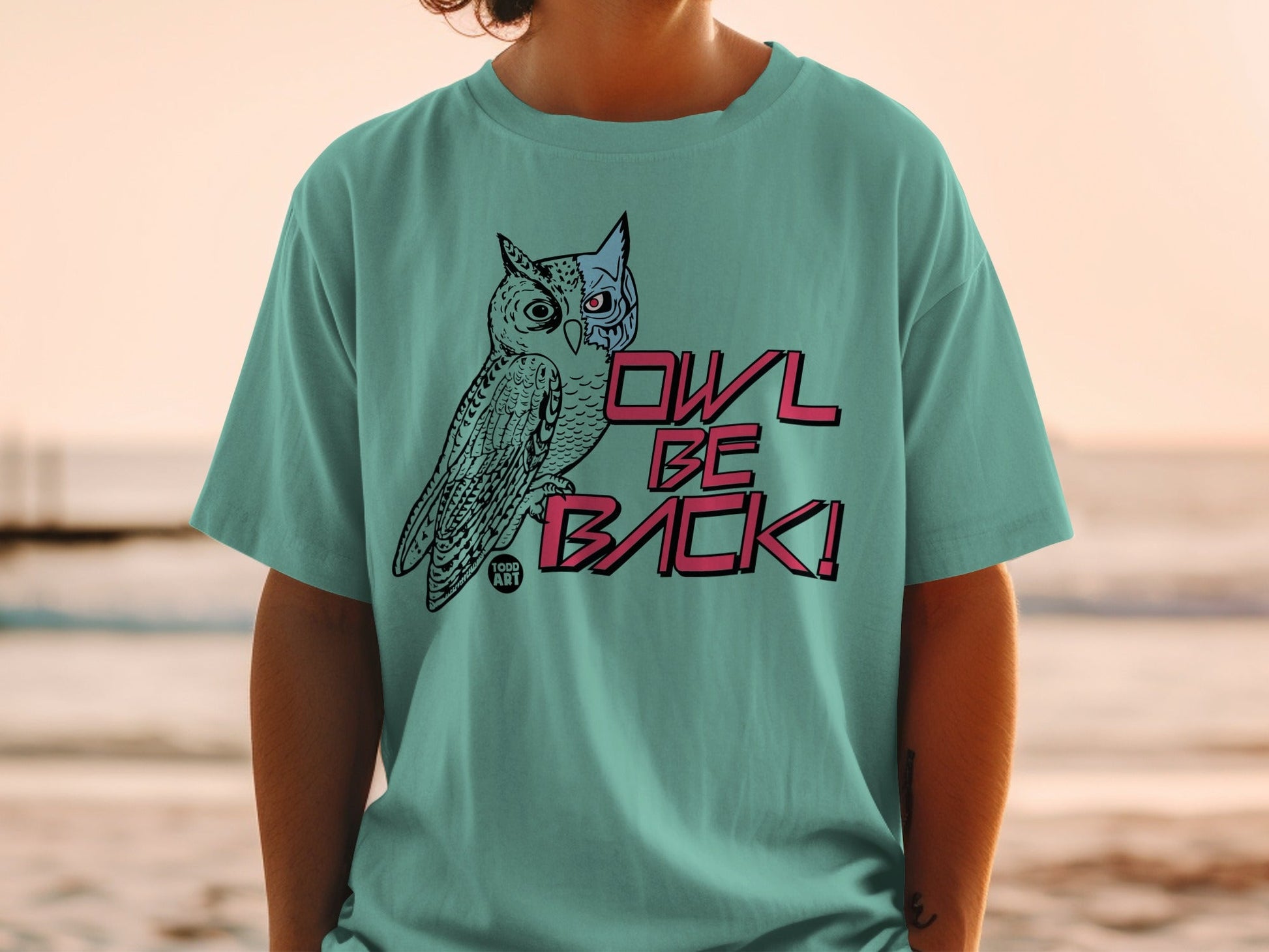 Teal t-shirt with stylized owl graphic and "OWL BE BACK!" text.