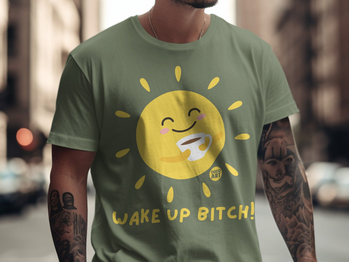 Olive green t-shirt with cartoon sun holding coffee and "Wake Up Bitch!" text.