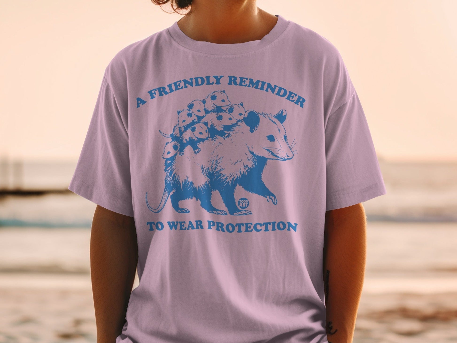 Blue graphic of an opossum with babies on its back and text "A friendly reminder to wear protection".