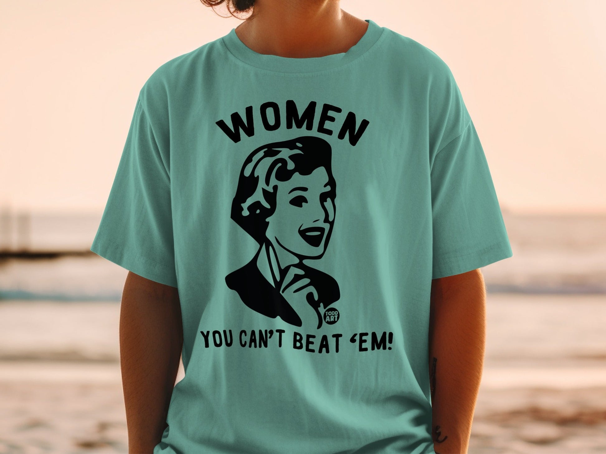 Teal t-shirt with "WOMEN YOU CAN'T BEAT 'EM!" retro slogan.