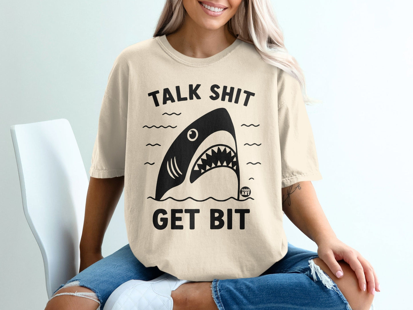 Cream t-shirt with shark graphic and text "TALK SHIT GET BIT".