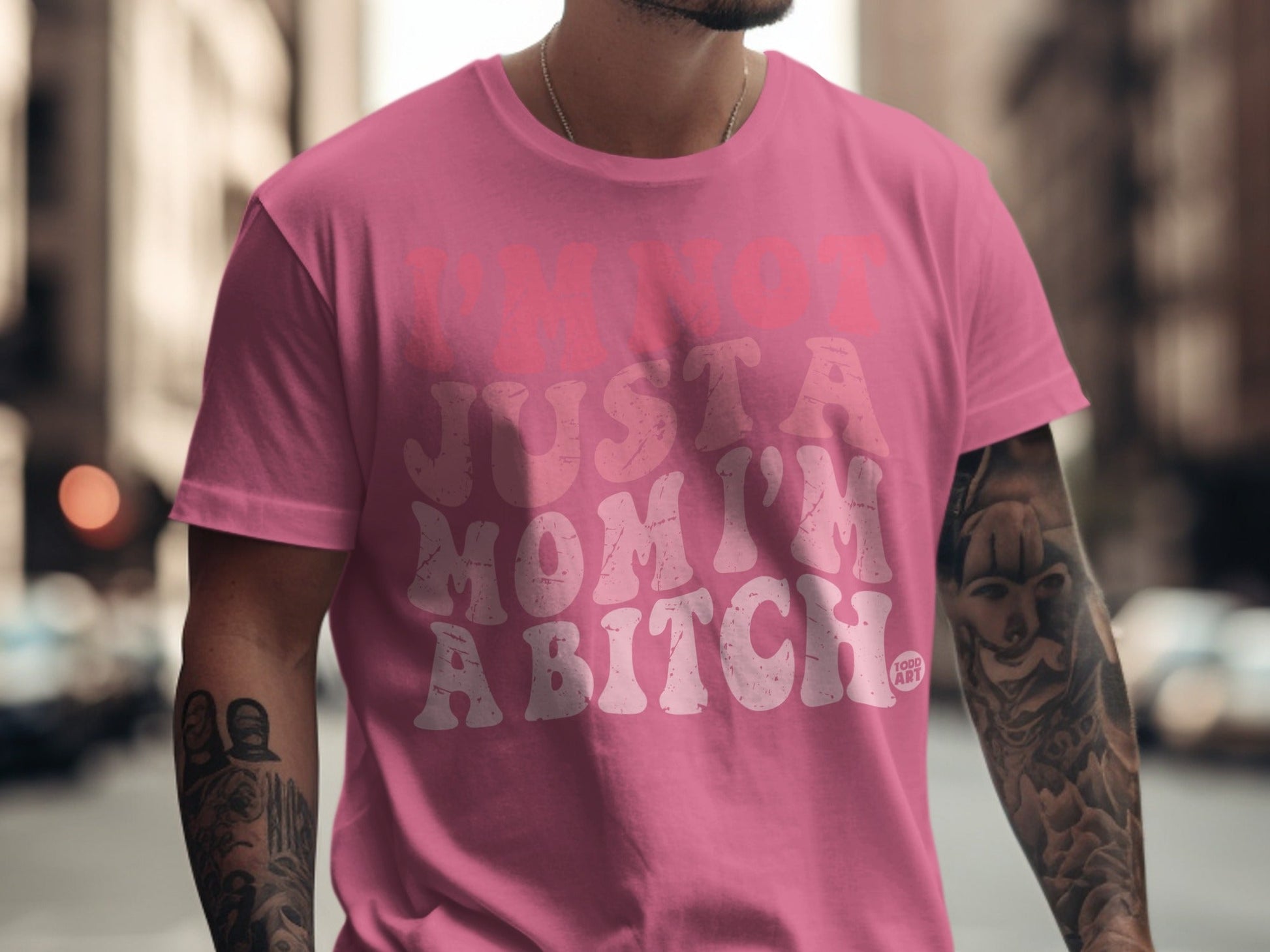 Pink t-shirt with white text reading "I'M NOT JUST A MOM I'M A BITCH."
