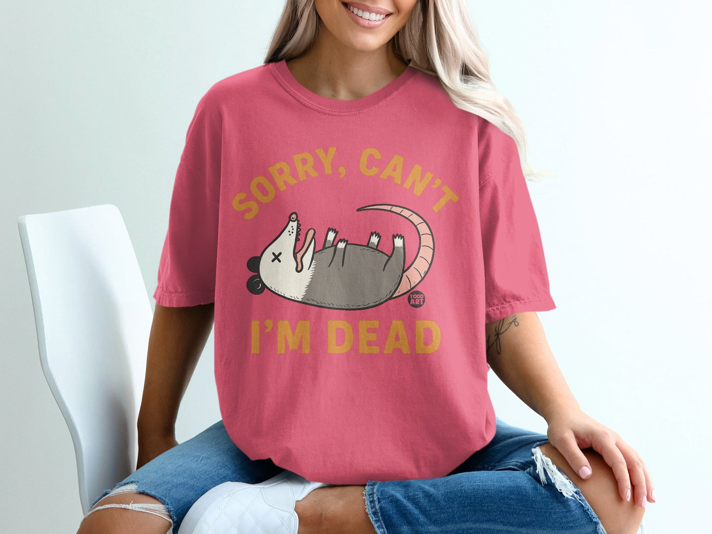 Pink t-shirt with possum graphic and text "SORRY, CAN'T I'M DEAD".