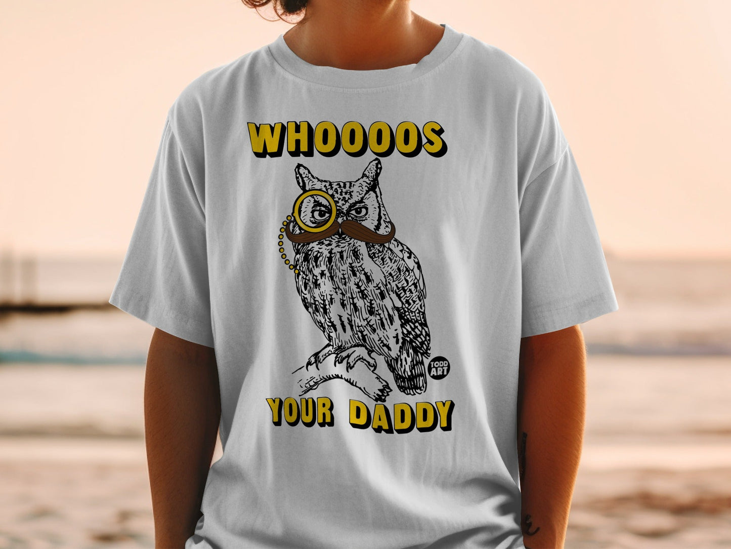 White t-shirt with a drawing of an owl wearing a monocle and mustache, reading "WHOOO'S YOUR DADDY".