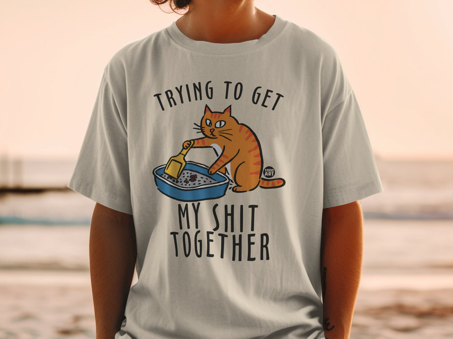 Orange cat in litter box with text "Trying to get my shit together".