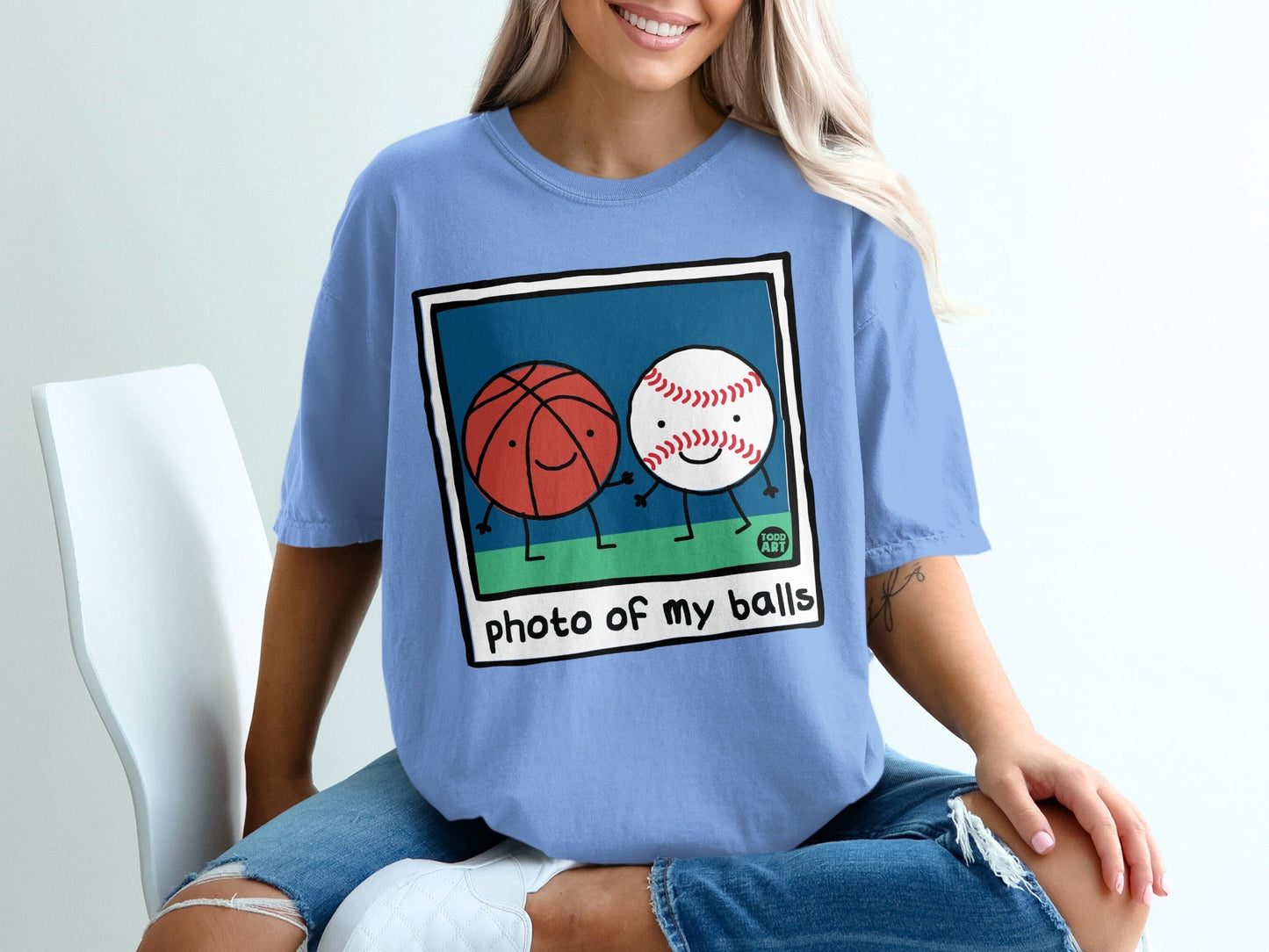 Cartoon basketball and baseball characters holding hands on shirt.