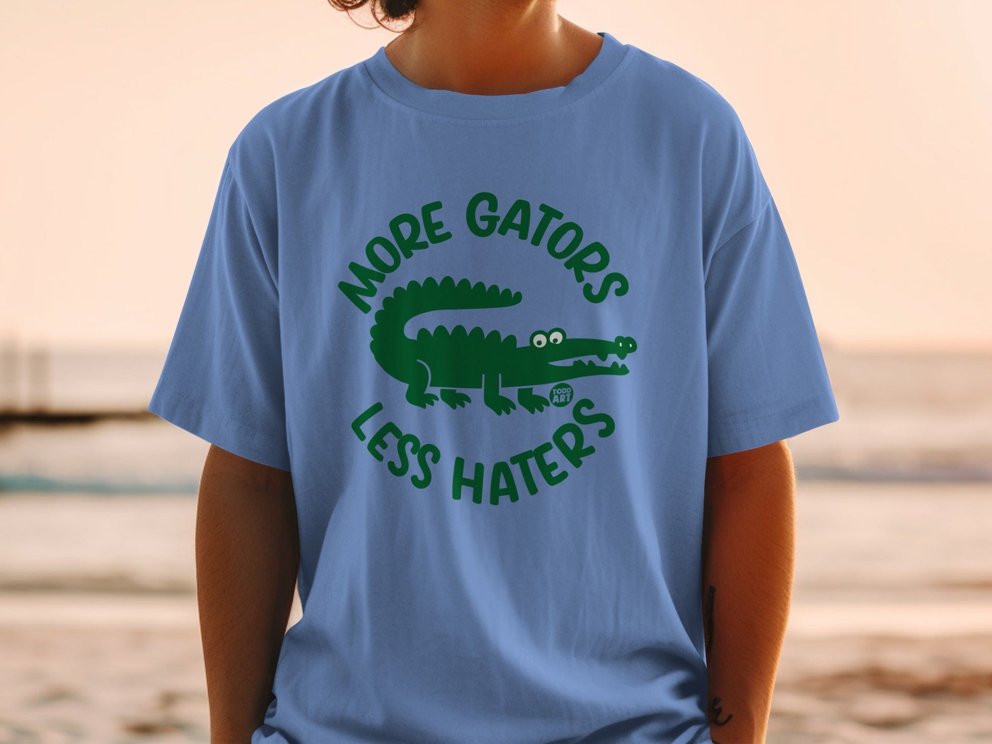 Blue t-shirt with green alligator graphic and text "More Gators Less Haters".