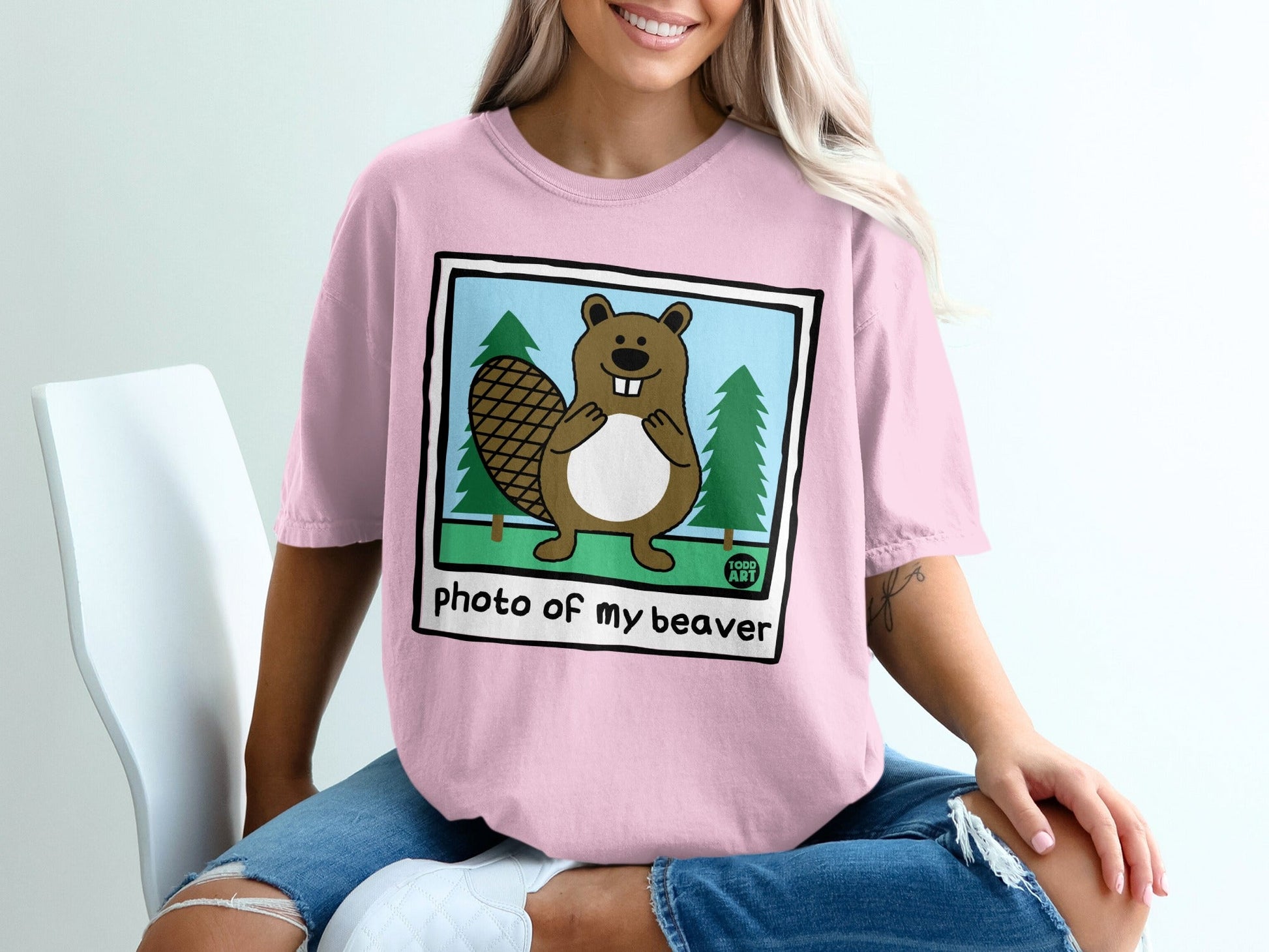 Pink t-shirt with a cartoon beaver on a polaroid frame, "photo of my beaver" text.