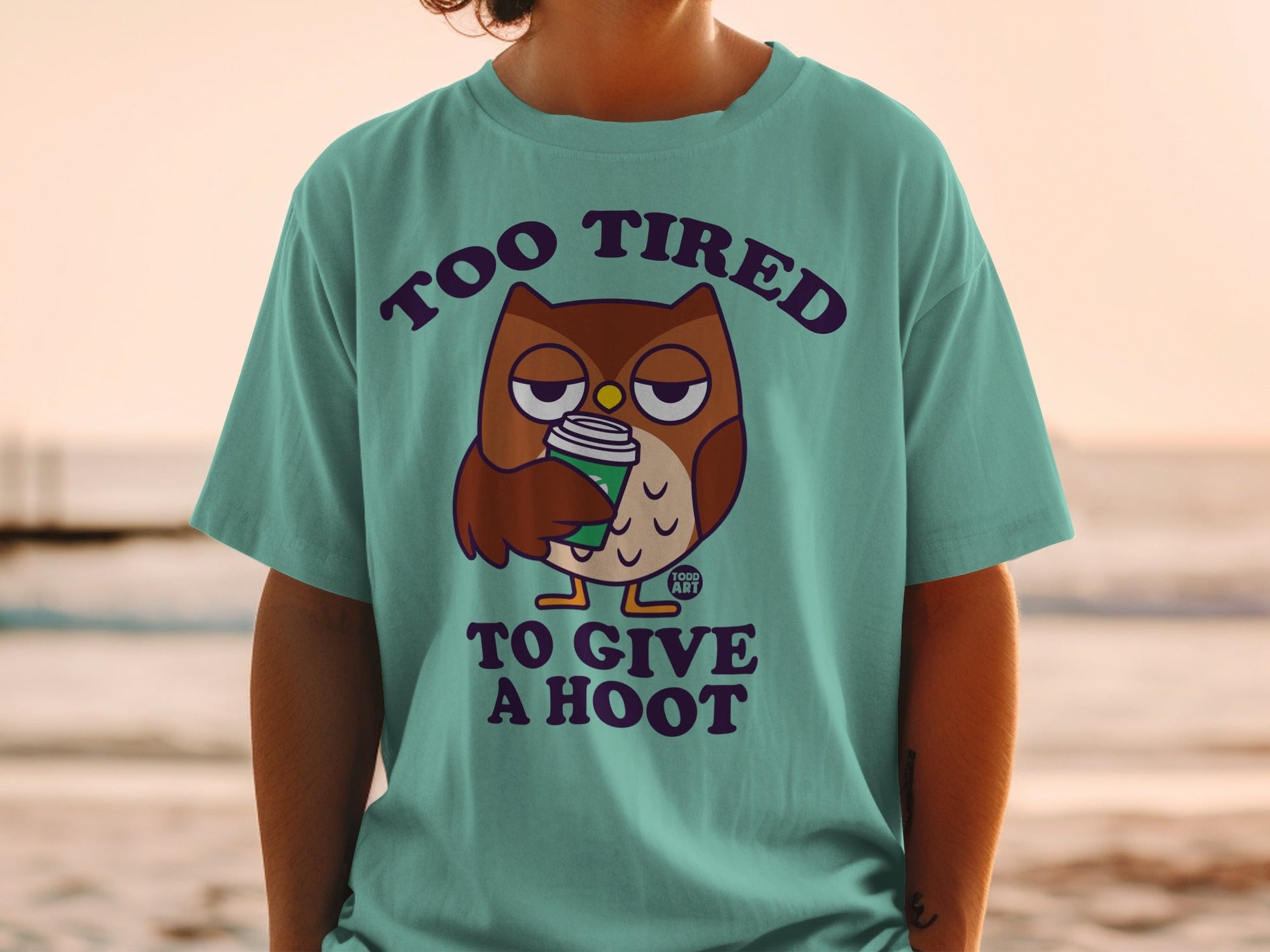 Teal t-shirt with owl holding coffee and text "Too Tired to Give a Hoot".