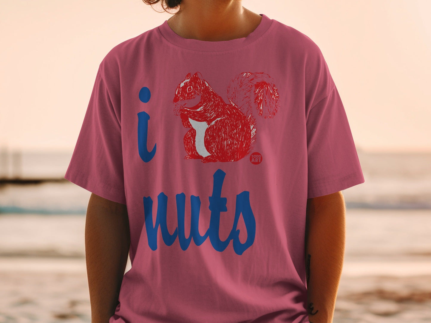 Pink t-shirt with blue text "i" and "nuts" and a drawing of a squirrel.