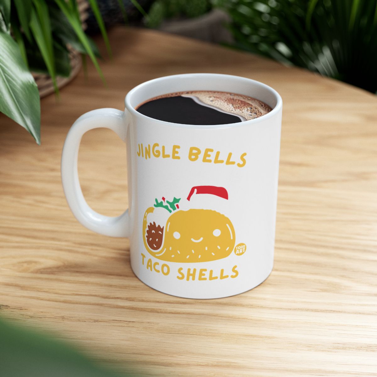 White mug with "Jingle Bells Taco Shells" and a taco in a Santa hat.