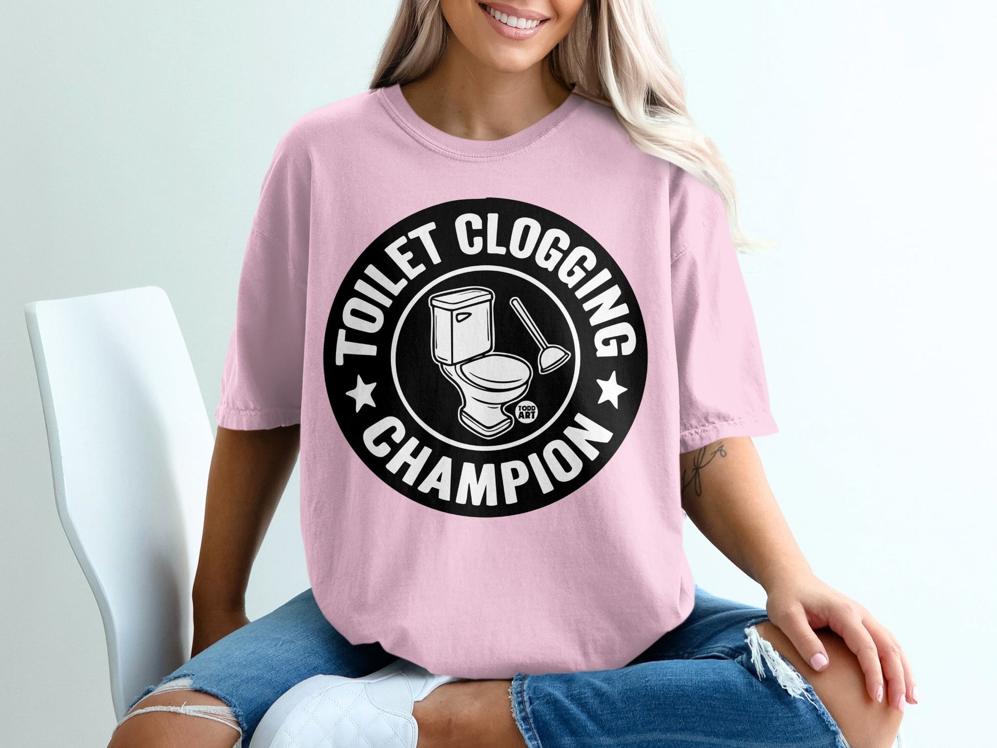 T-shirt with "Toilet Clogging Champion" text and toilet graphic.
