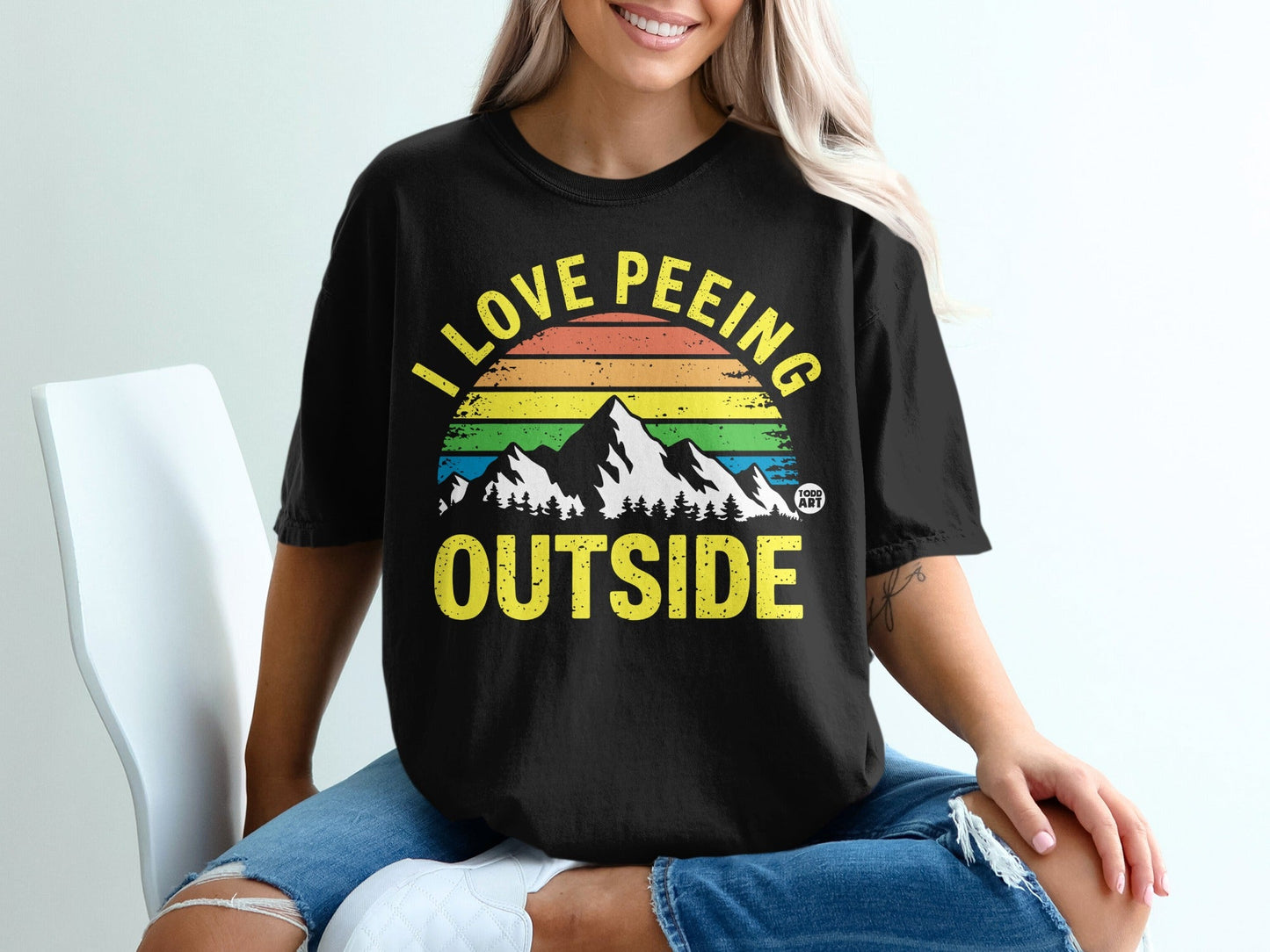 Black t-shirt with rainbow mountains and "I LOVE PE**ING OUTSIDE" text.